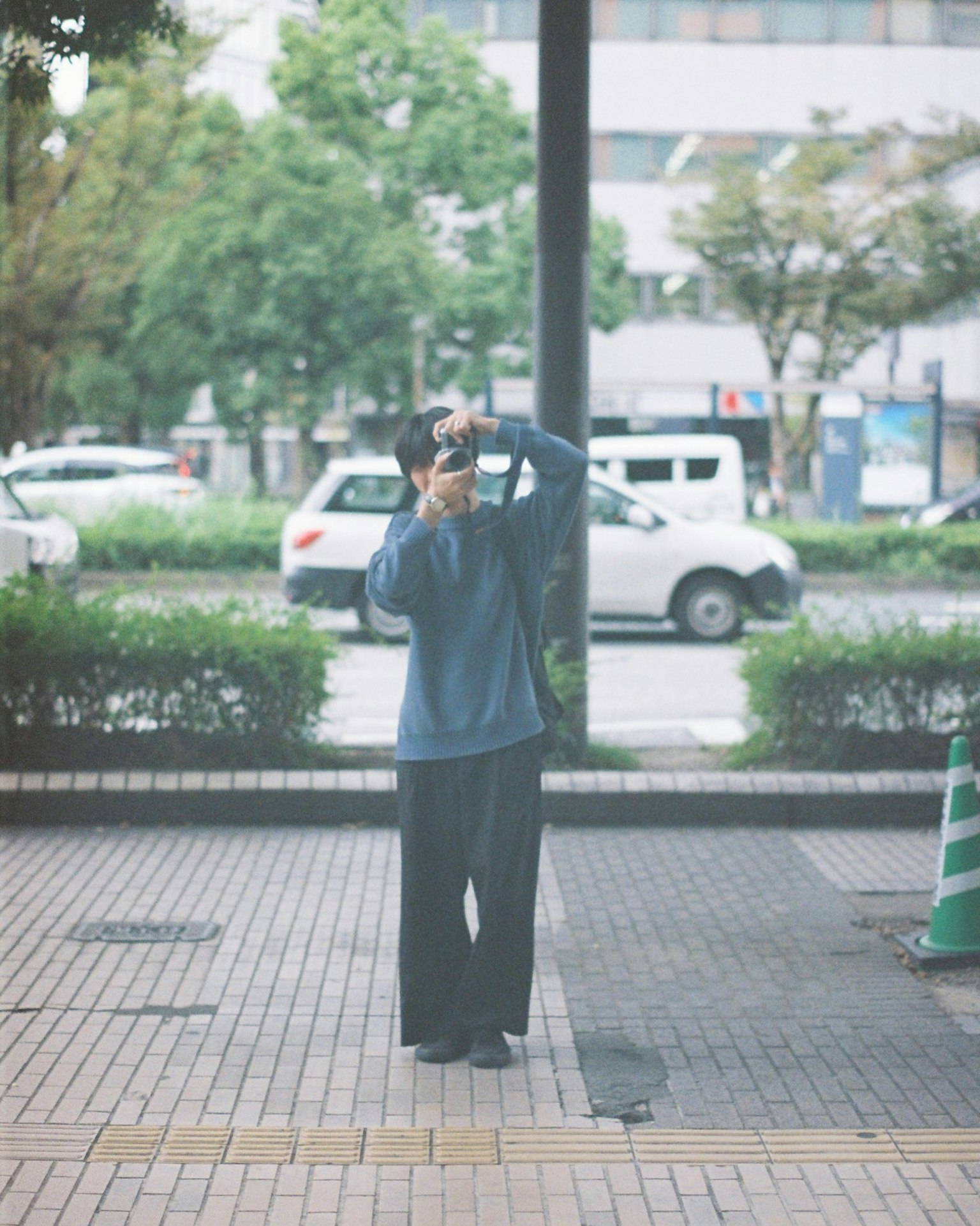 Persona con una macchina fotografica di spalle in un contesto urbano