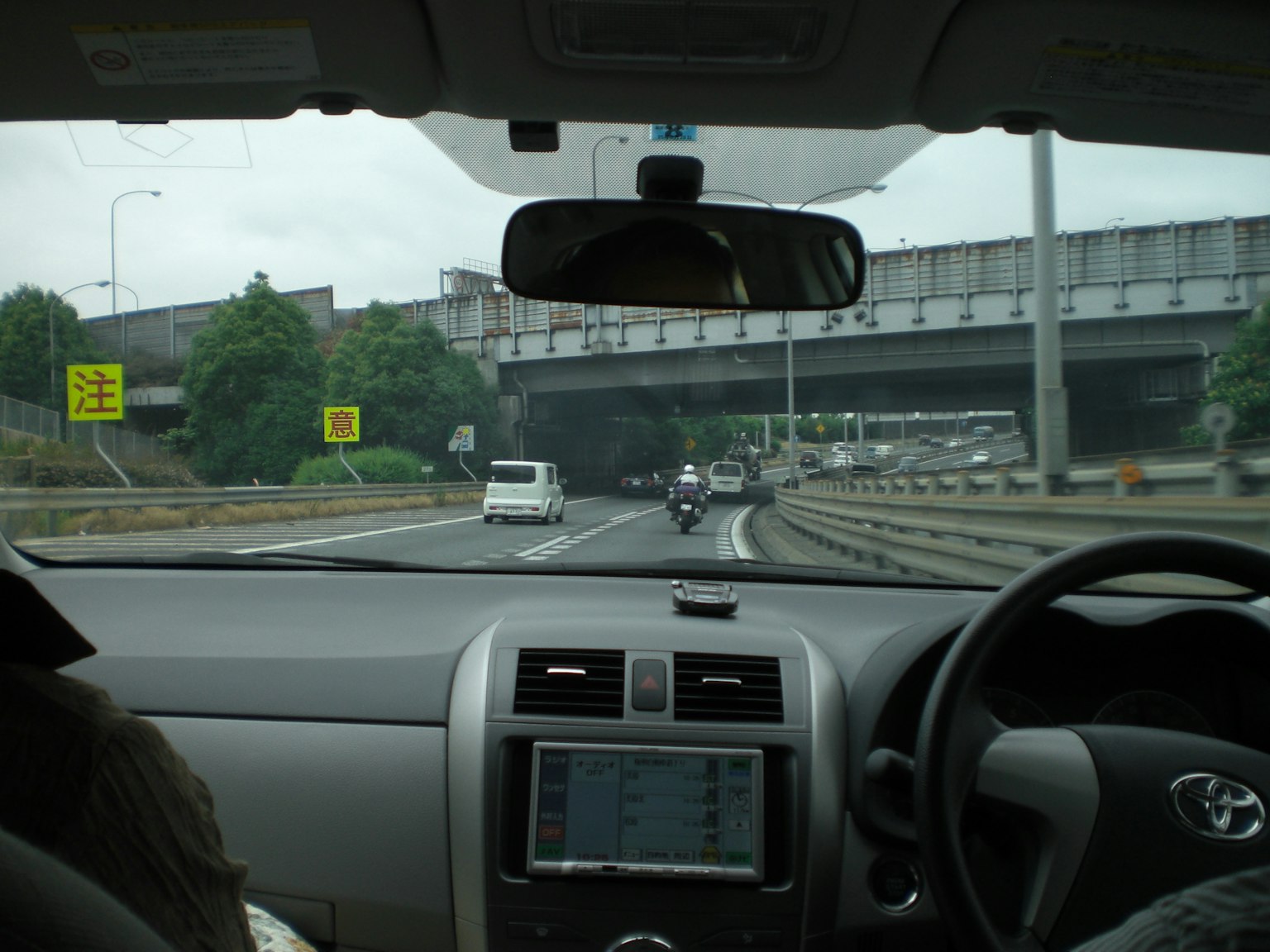 Vista de una autopista desde dentro de un coche tablero visible con la mano del conductor