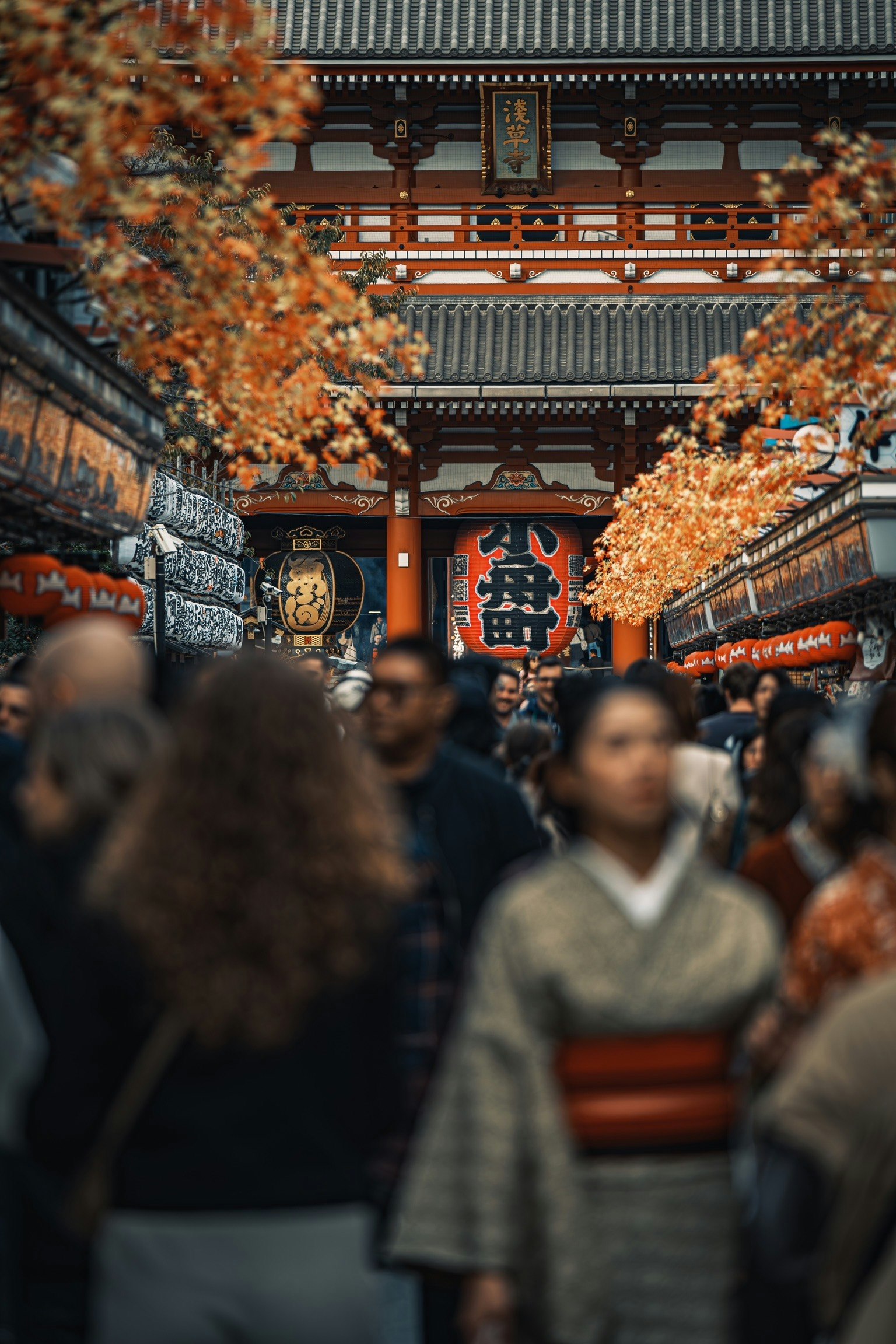 calle concurrida frente al templo Senso-ji en Asakusa, hojas de arce de otoño