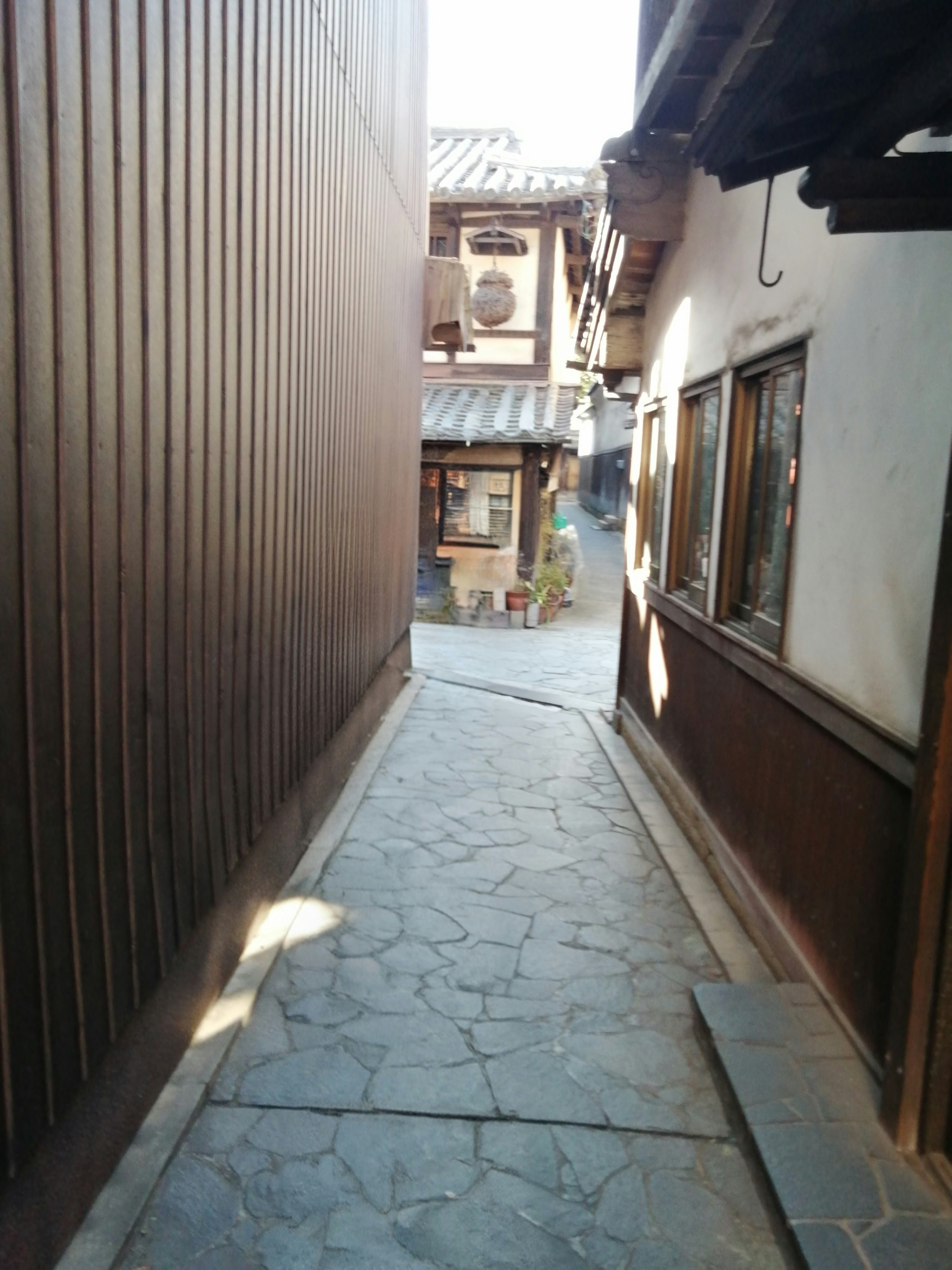 ตรอกปูพื้นหินพร้อมหน้าร้านและกรอบไม้