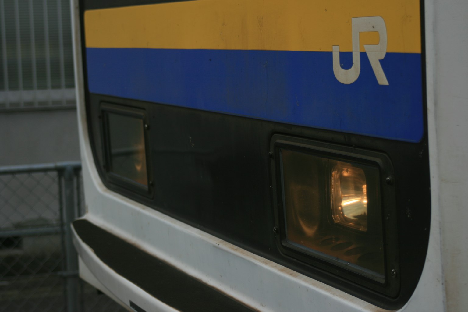 Close-up of a JR train front featuring lights and logo
