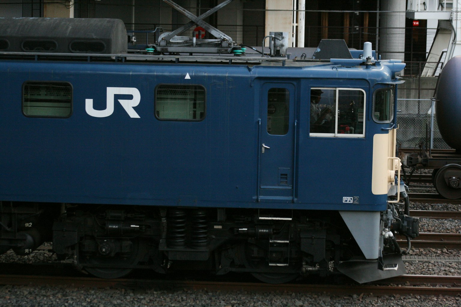 Vista lateral de un tren JR azul con logo claro