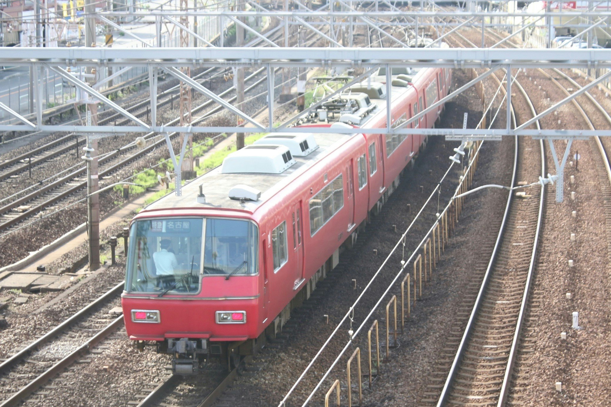 線路を走る赤い電車の車両とホームの風景