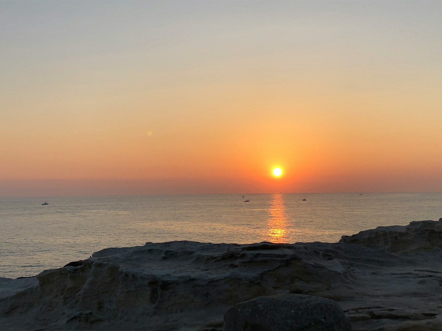 Beautiful sunset over the ocean with rocky foreground