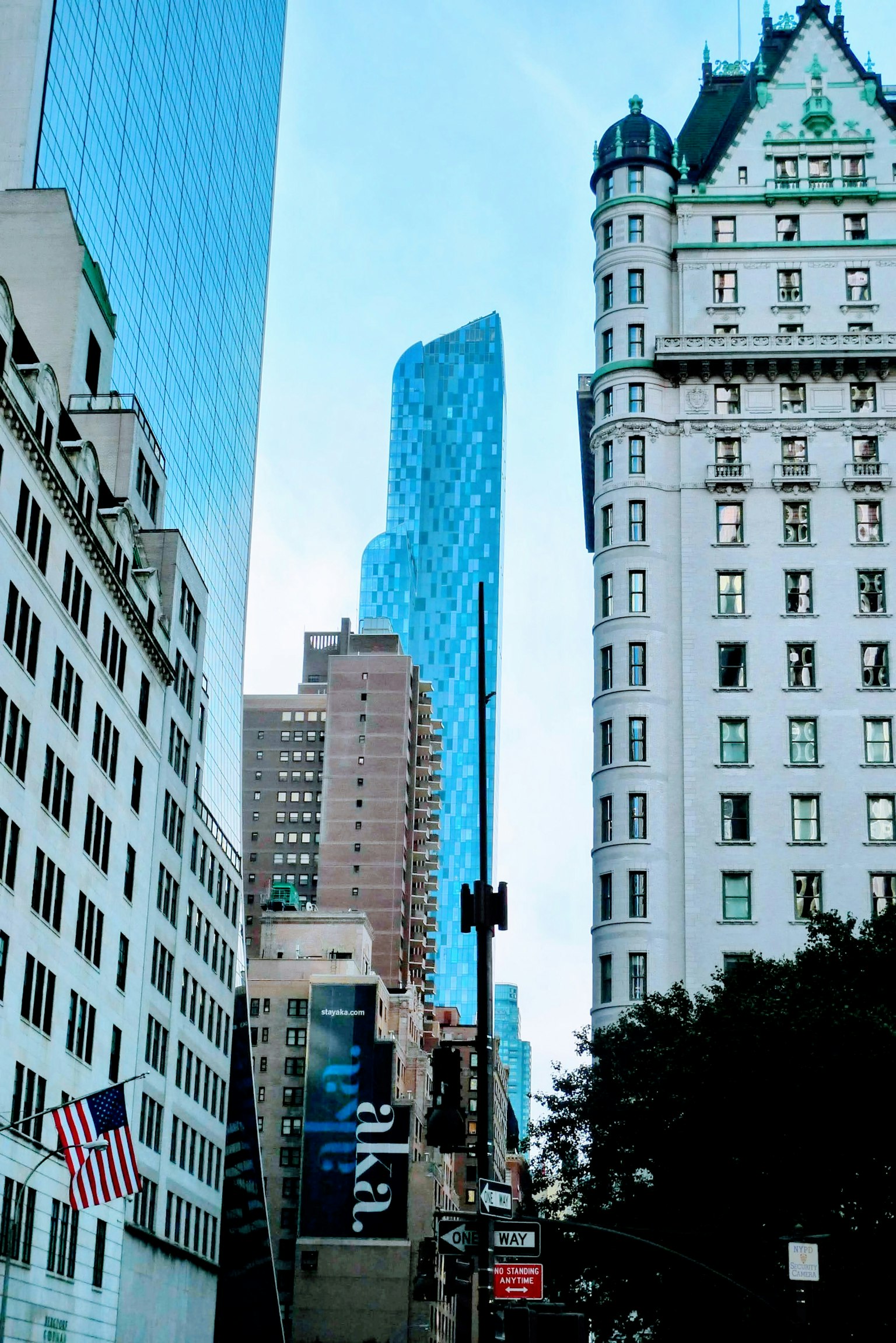 Un paisaje urbano con rascacielos que incluyen una estructura de vidrio azul y un edificio histórico