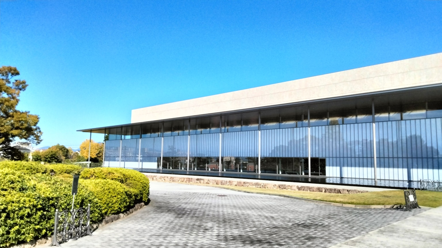 Architecture moderne avec une façade en verre sous un ciel bleu clair