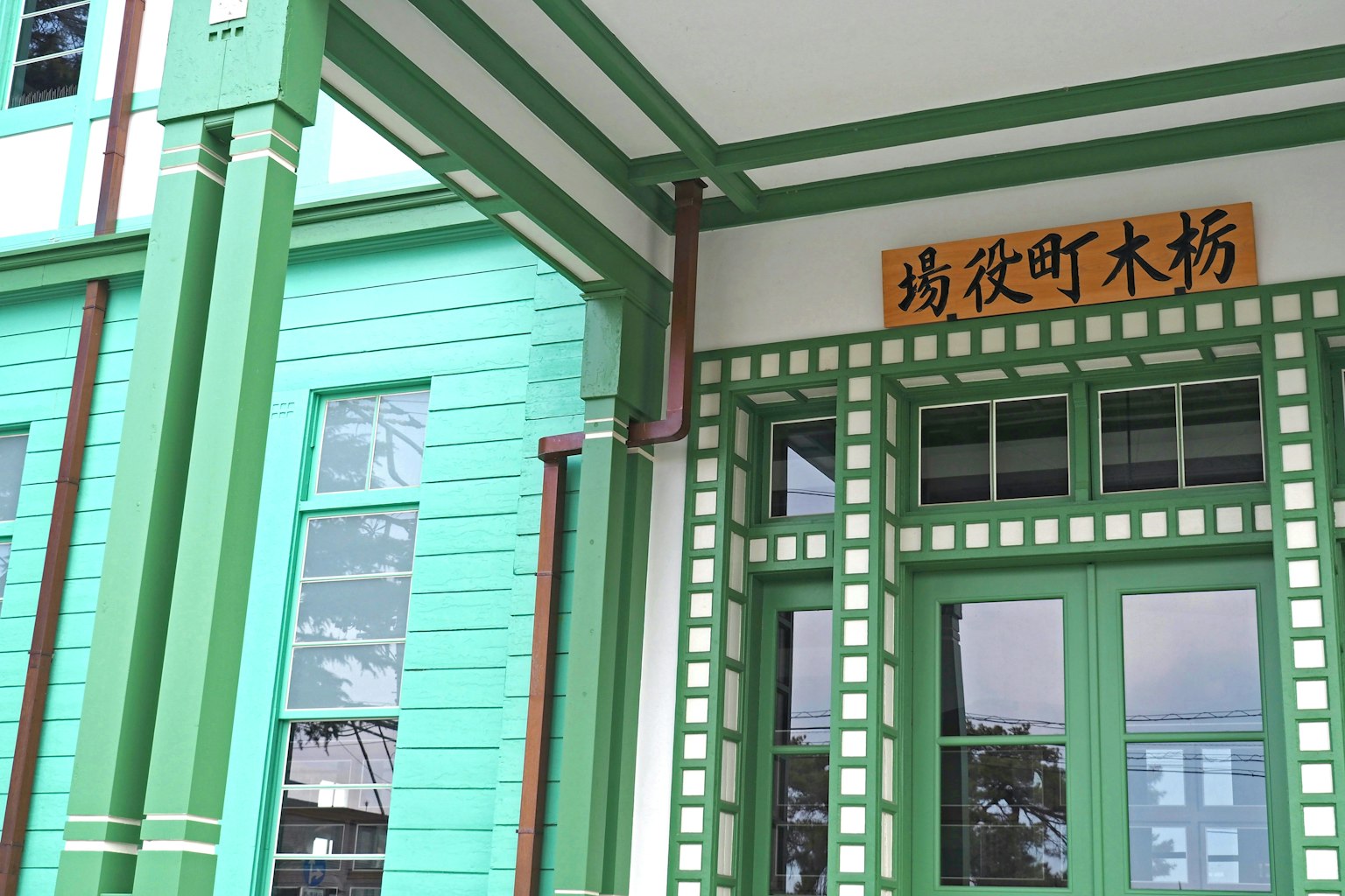 绿色建筑的外观，特色木门和显眼的招牌