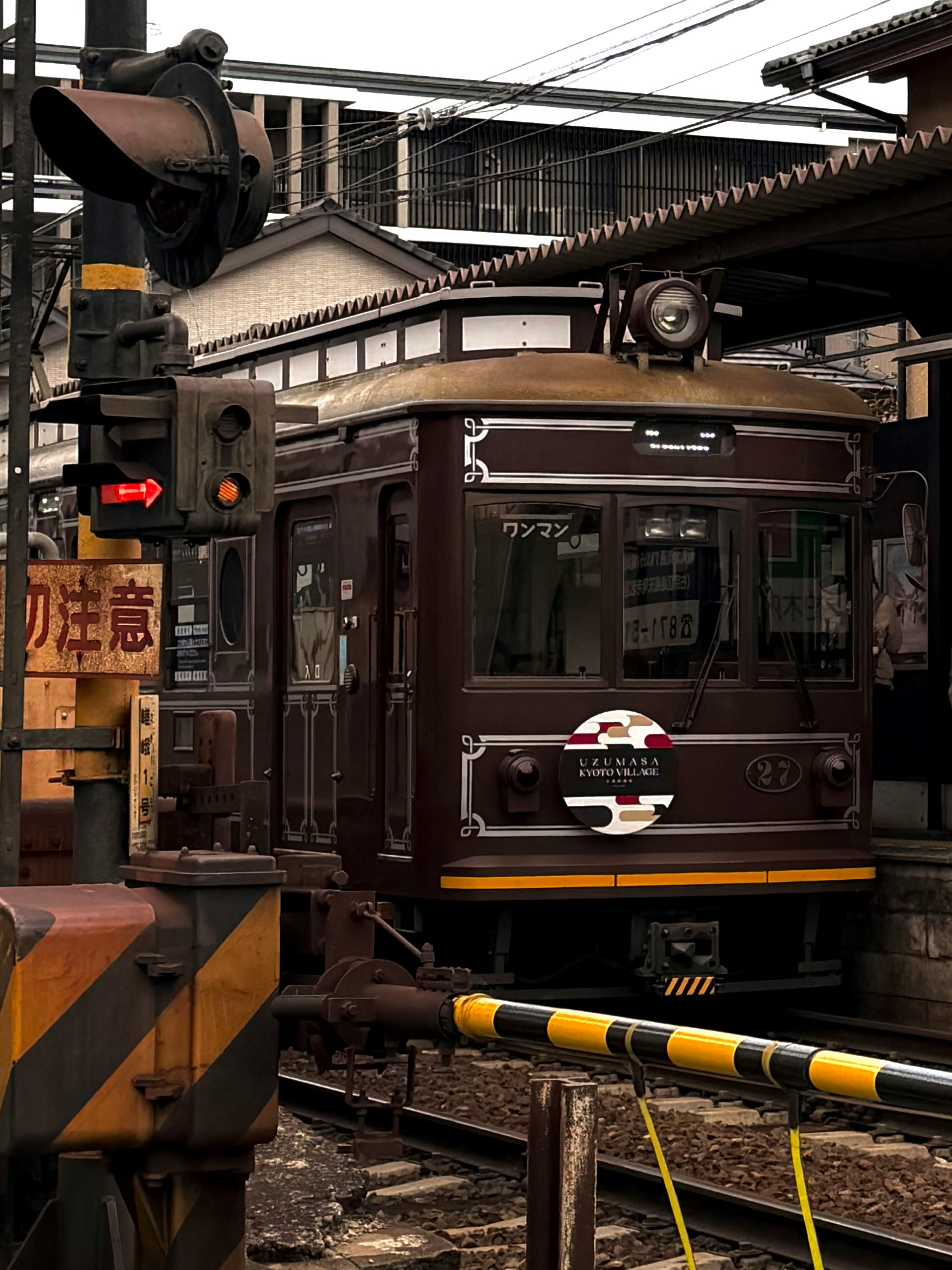 古いスタイルの茶色い電車が駅に停車している風景
