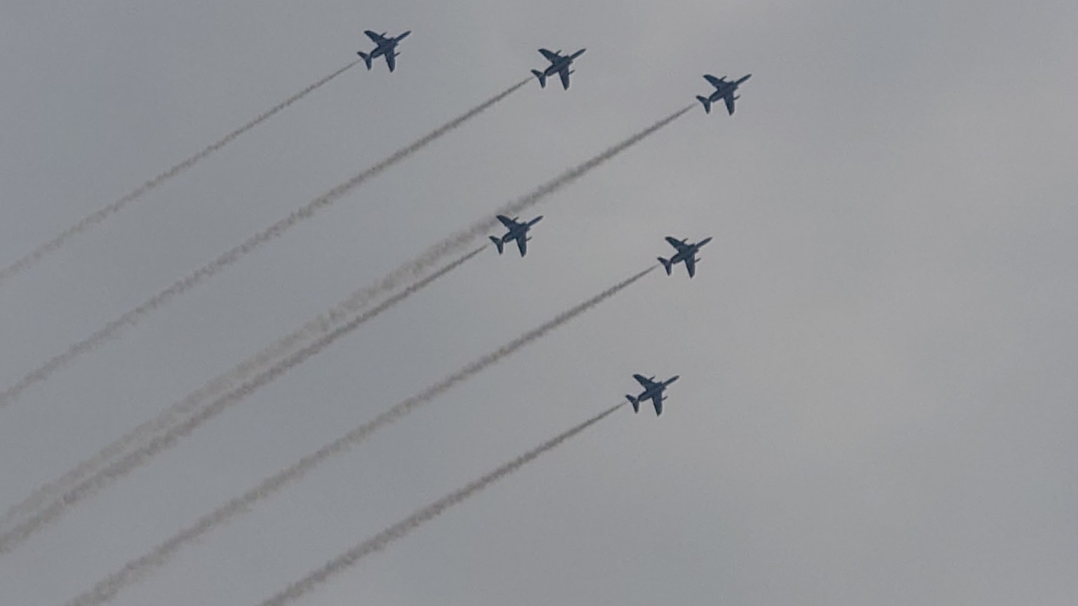 Sechs Kampfjets fliegen in Formation und hinterlassen Rauchspuren