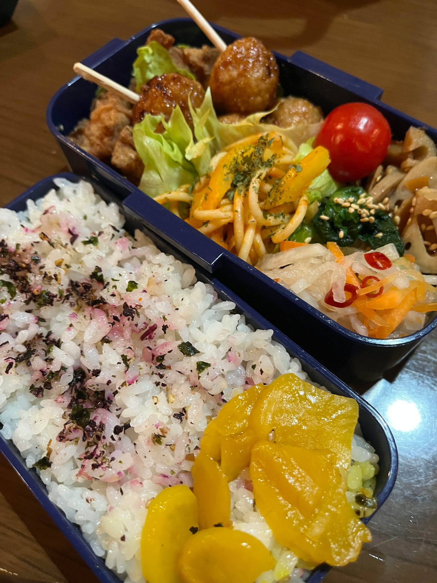 Delizioso bento con riso bianco, spiedini di pollo grigliato, insalata di verdure, pomodorini e frutta
