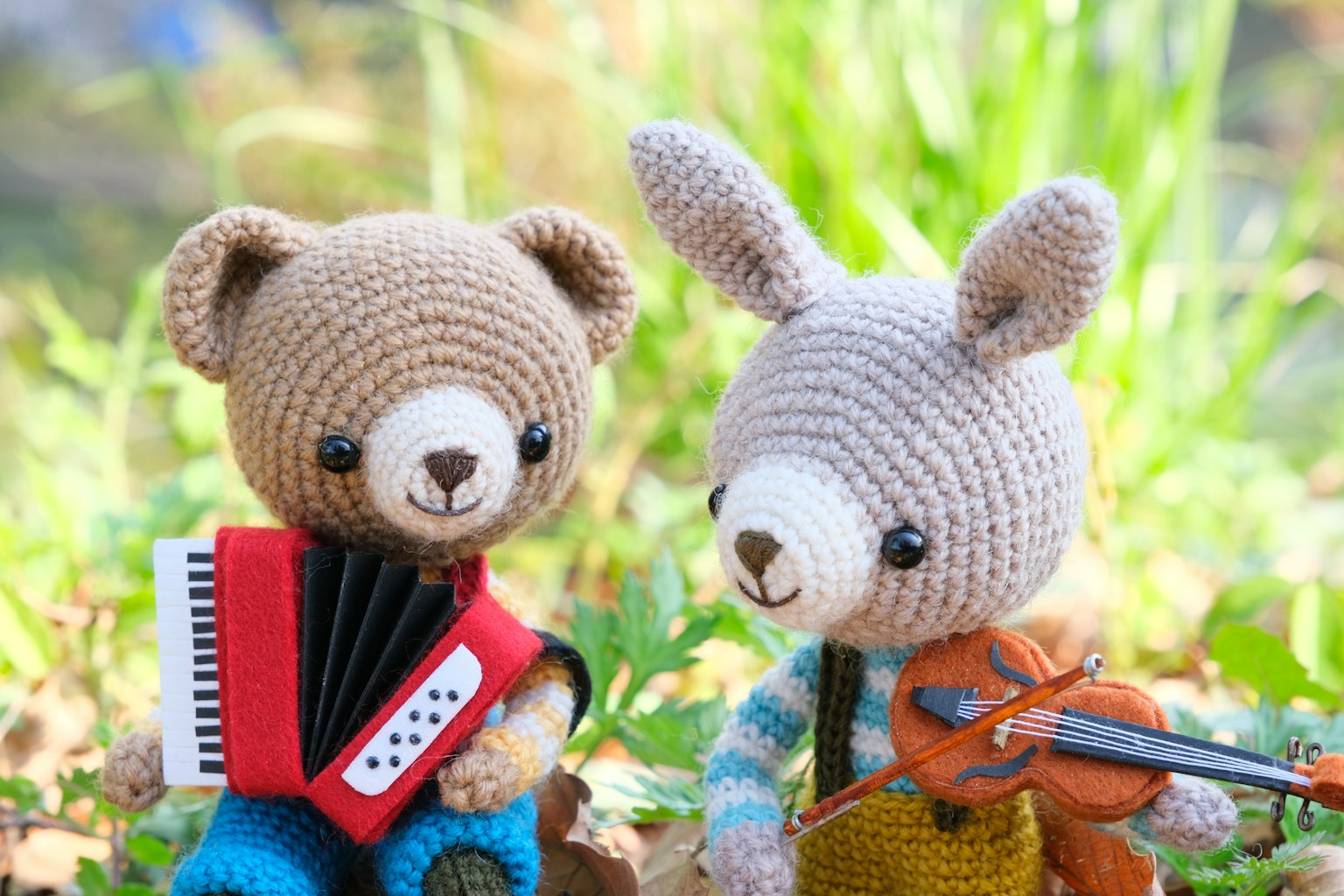 Un ours et un lapin en crochet tenant des instruments de musique