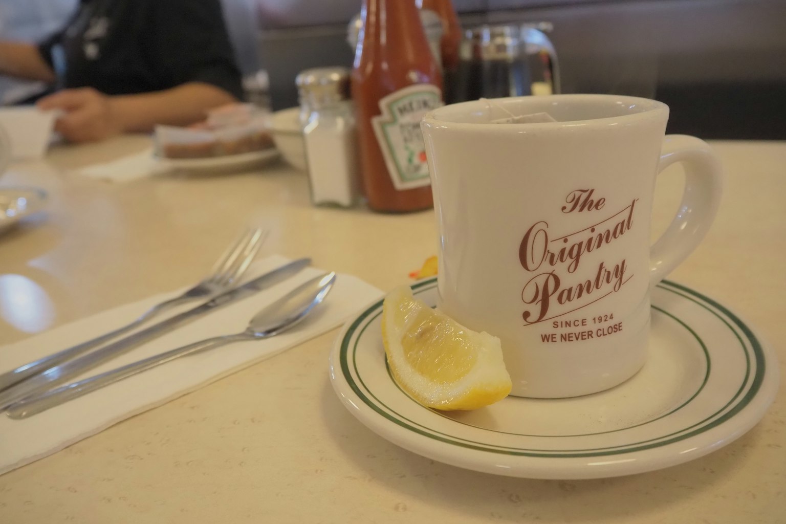 Kaffeetasse von The Original Pantry mit einer Zitronenscheibe