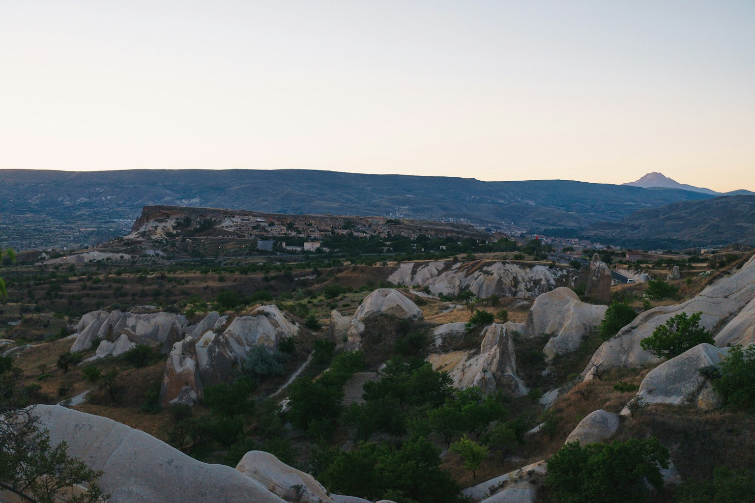 Paysage crépusculaire avec des collines rocheuses et des montagnes lointaines