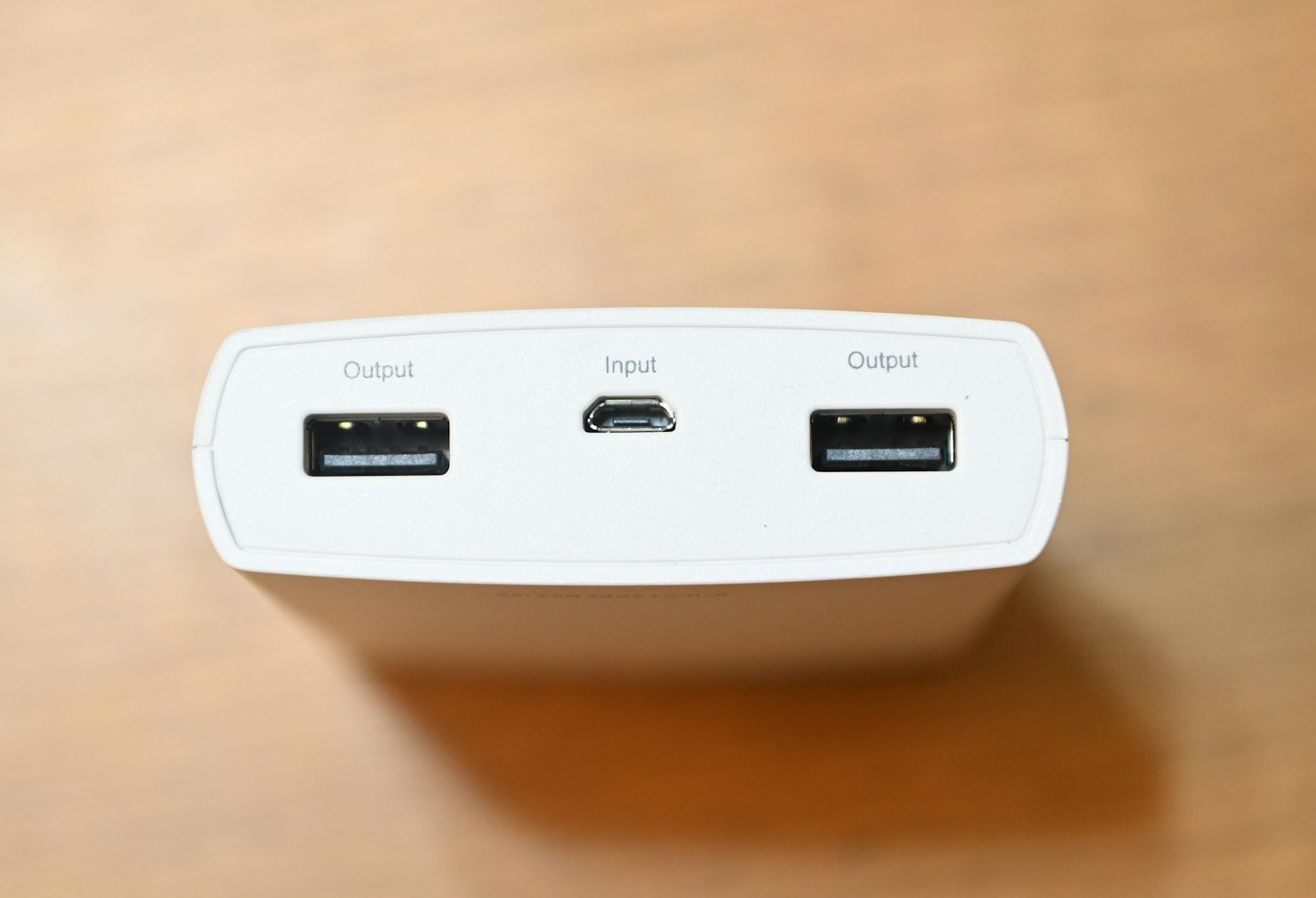 Góc nhìn từ trên xuống của pin di động màu trắng với hai cổng USB và một cổng micro USB