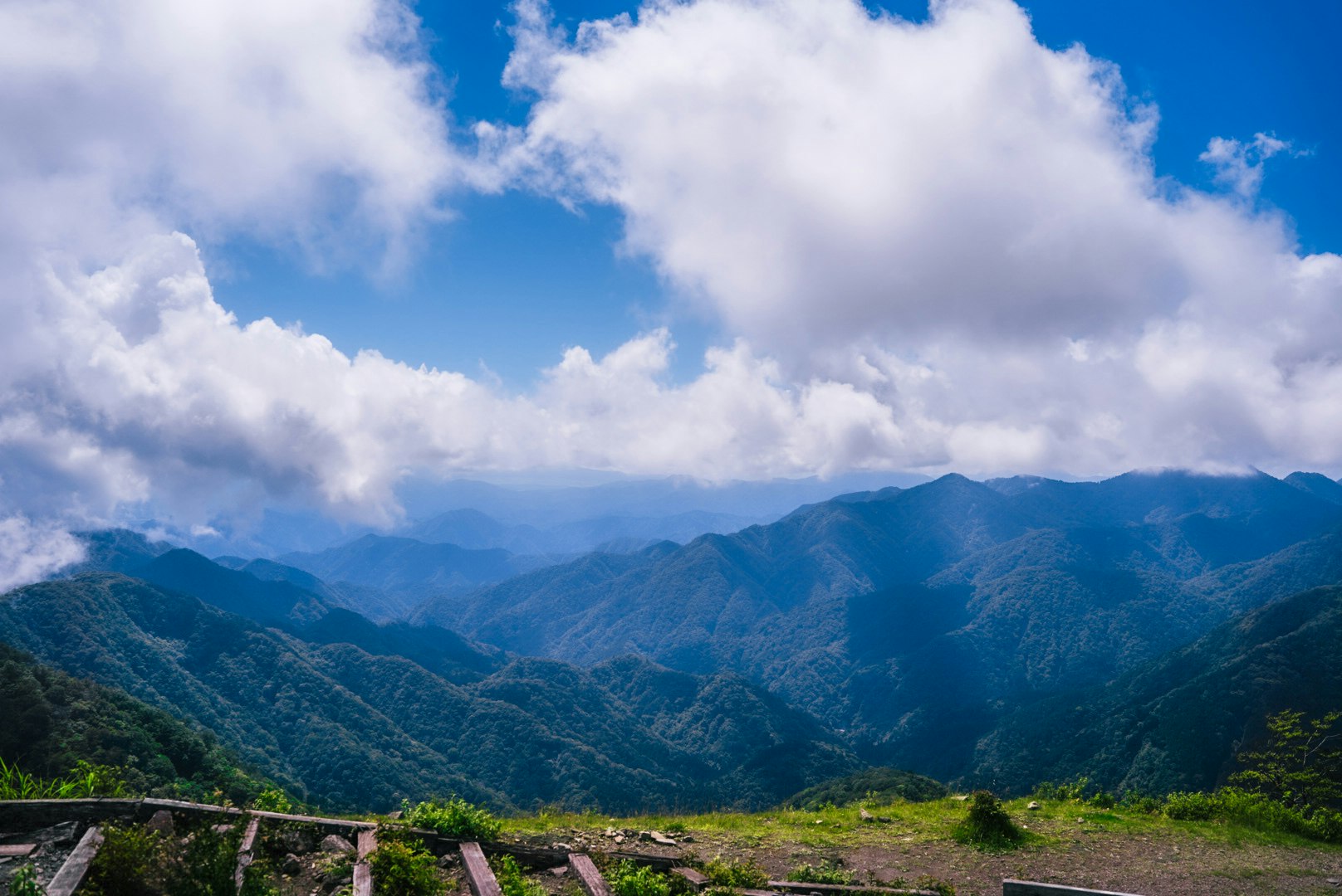 vue d’une vallée de montagne verte depuis un belvédère