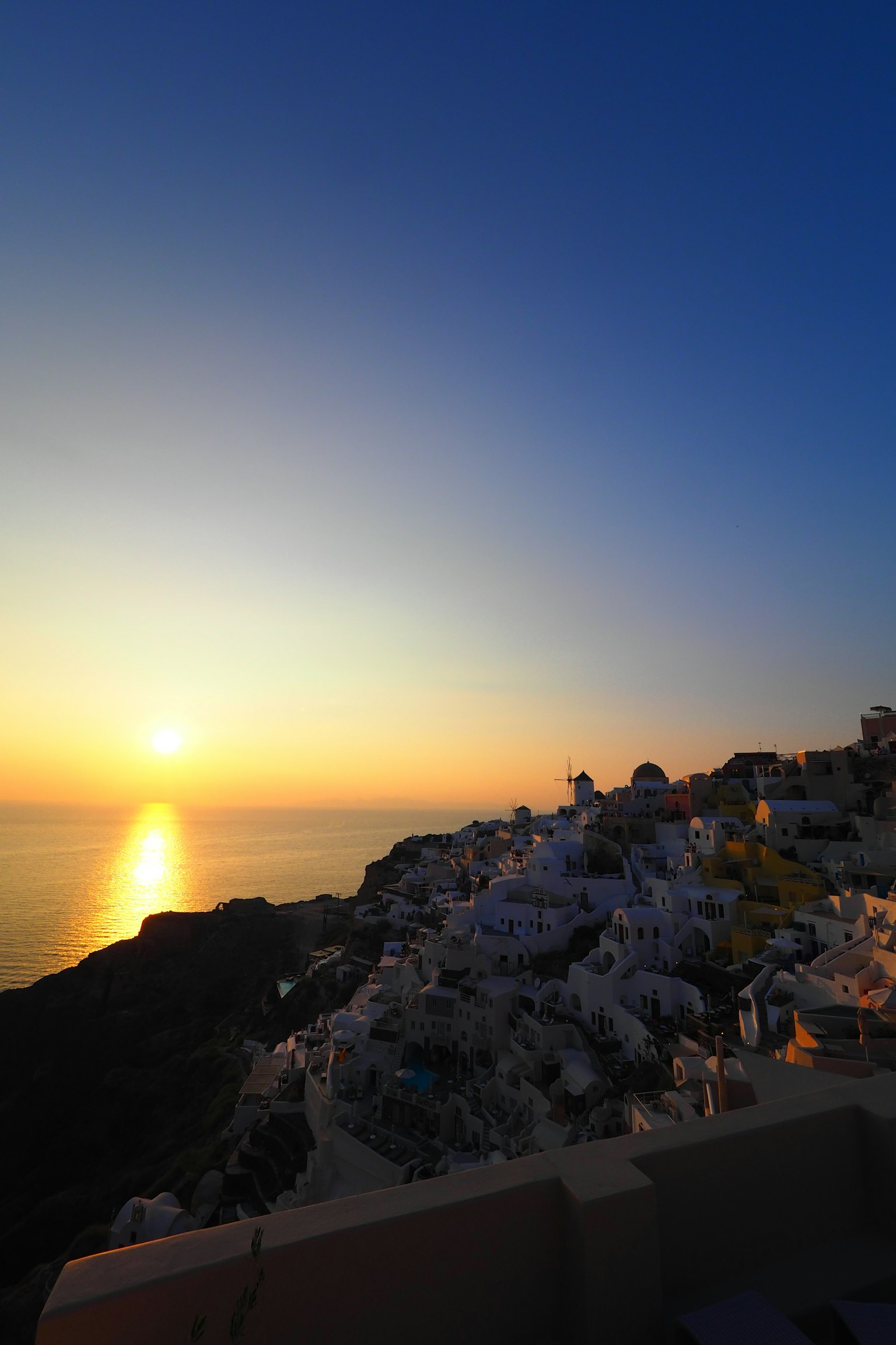 Beautiful sunset over the sea with white buildings in Santorini