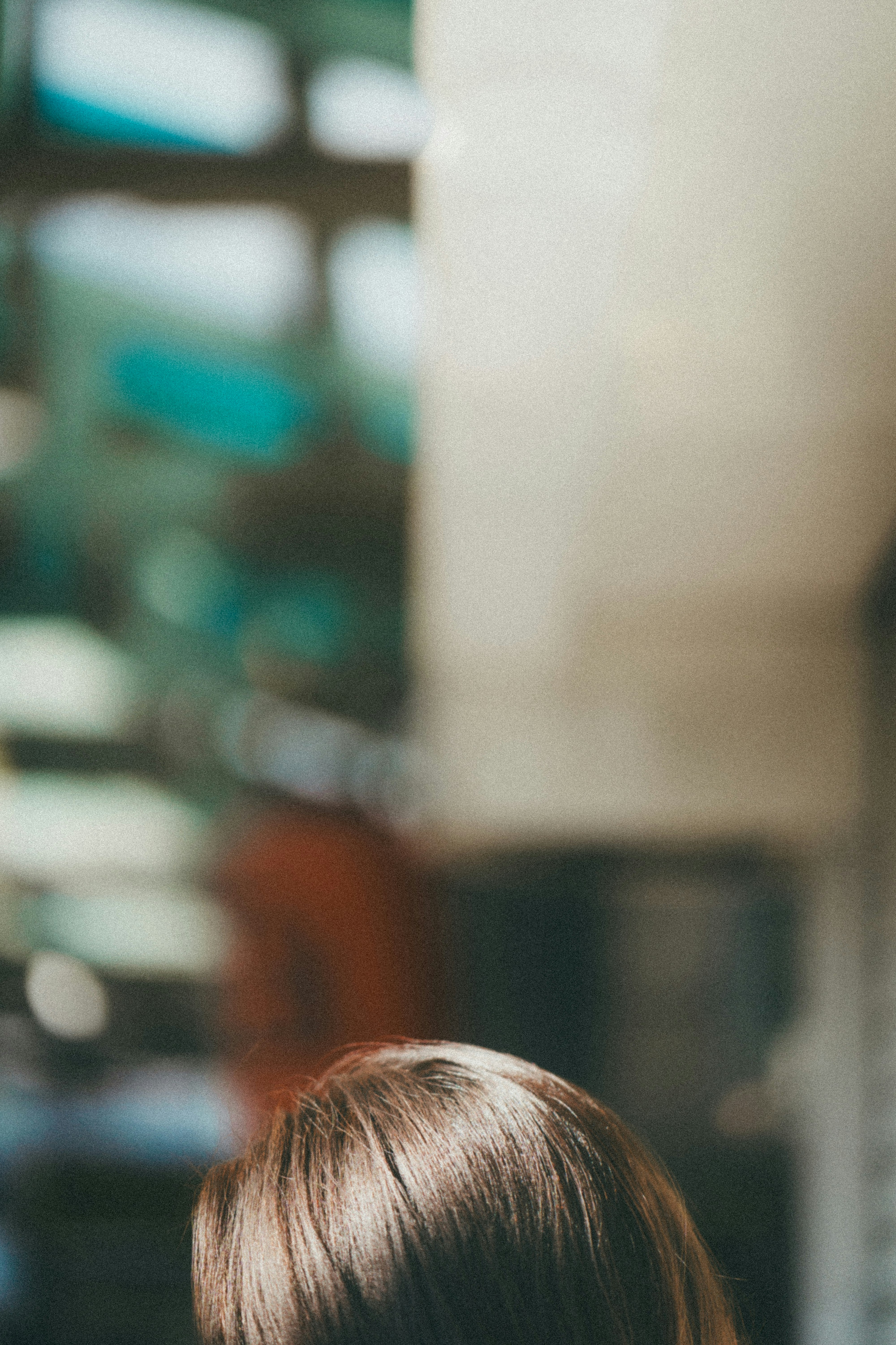 side profile of a person indoors in front of bookshelves