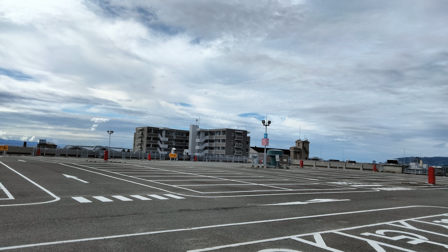 宽敞的停车场与阴云密布的天空和远处的建筑