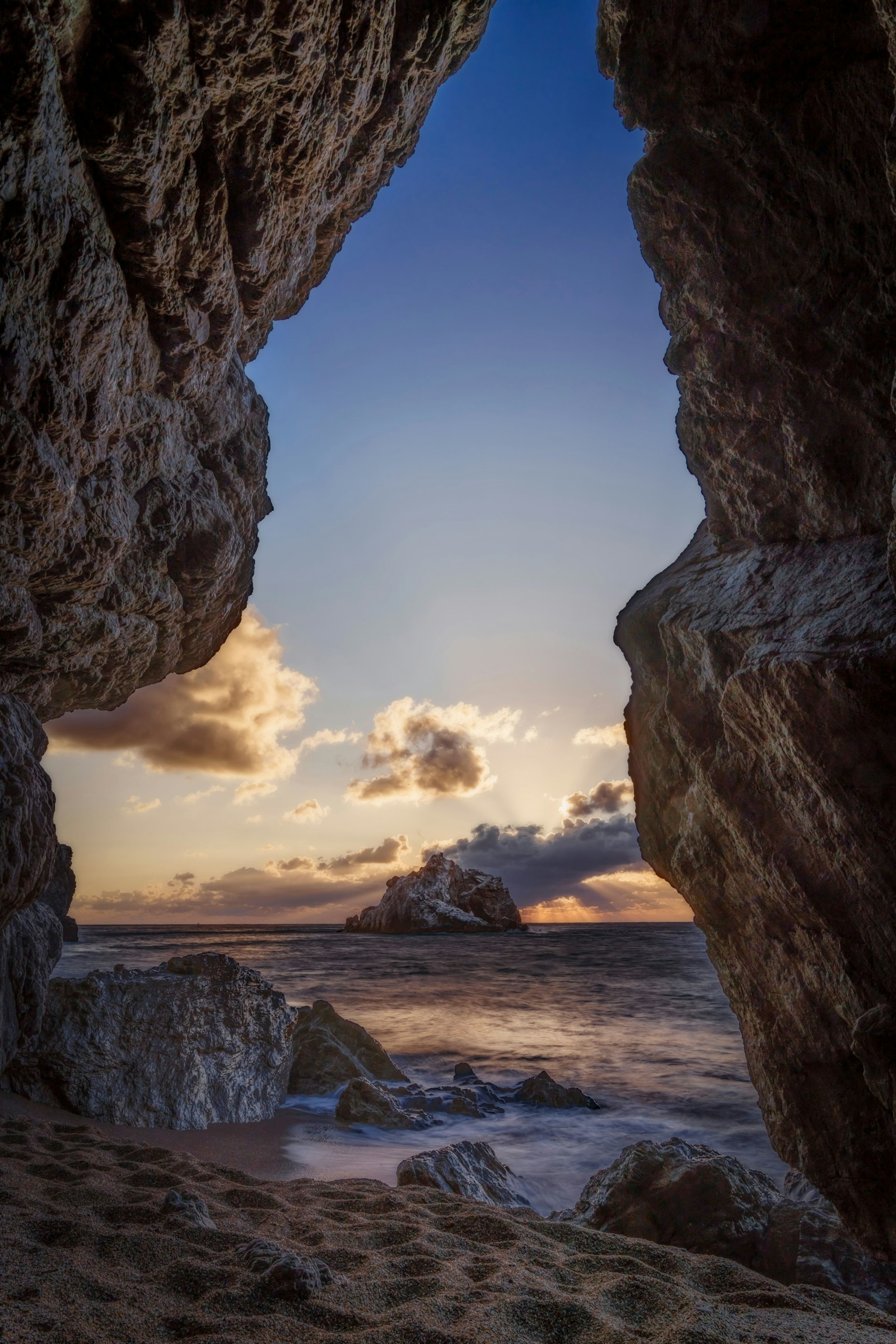Vue de l'océan et du coucher de soleil à travers des formations rocheuses