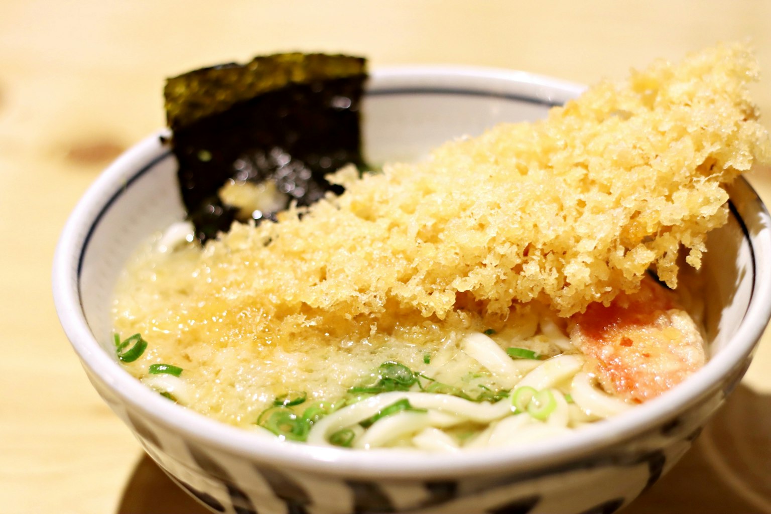 Mangkuk ramen yang dihiasi dengan makanan goreng renyah dan rumput laut