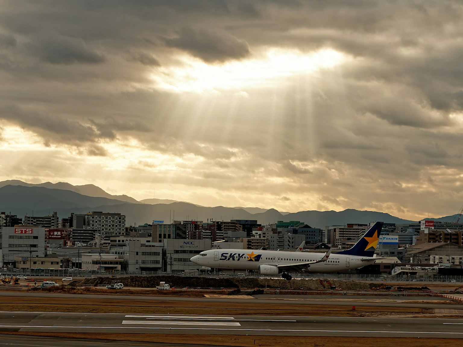 Avion à l'aéroport avec ciel nuageux et rayons de soleil
