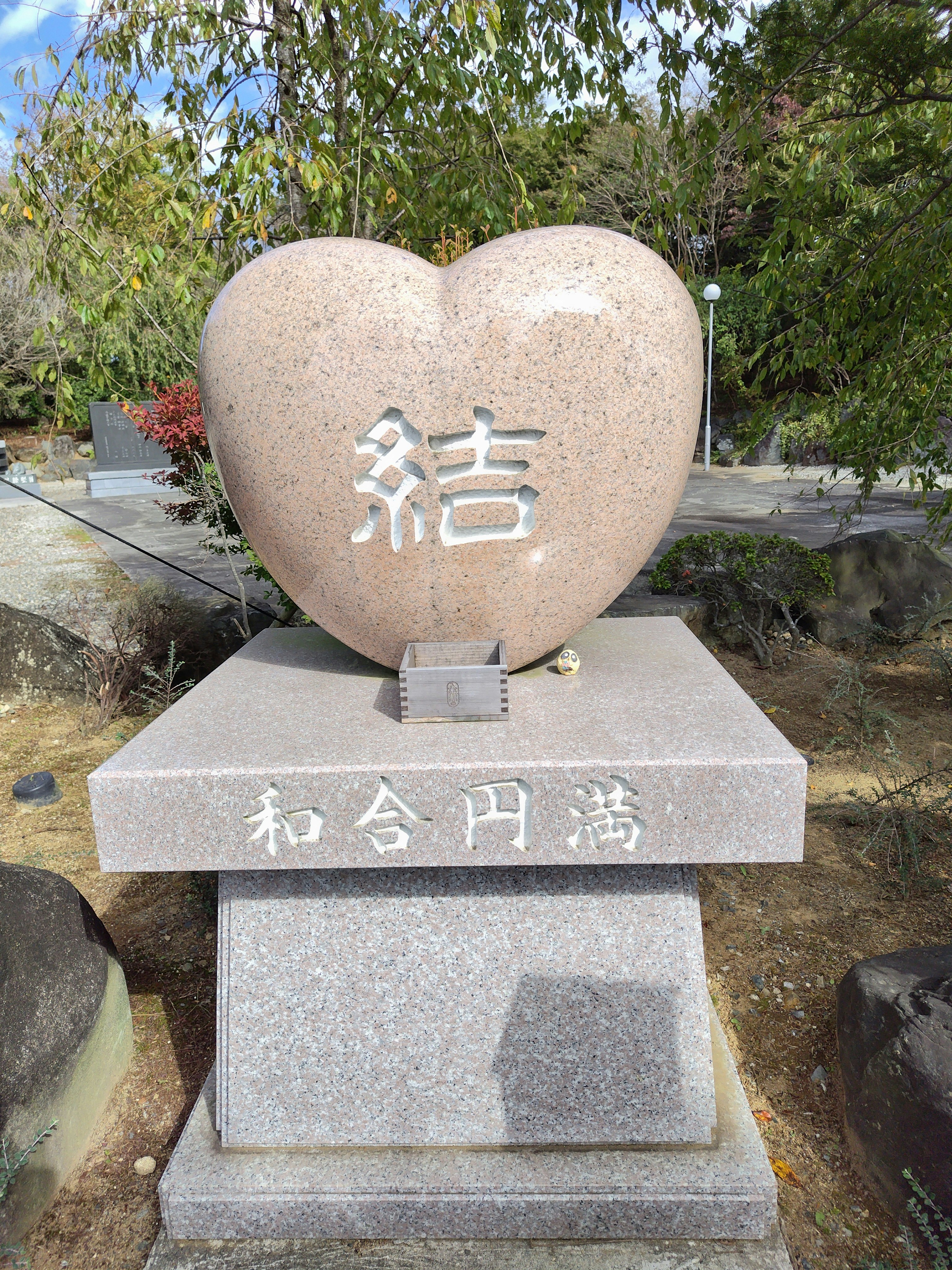 Heart-shaped memorial stone with engraved “結” and “和合円満”
