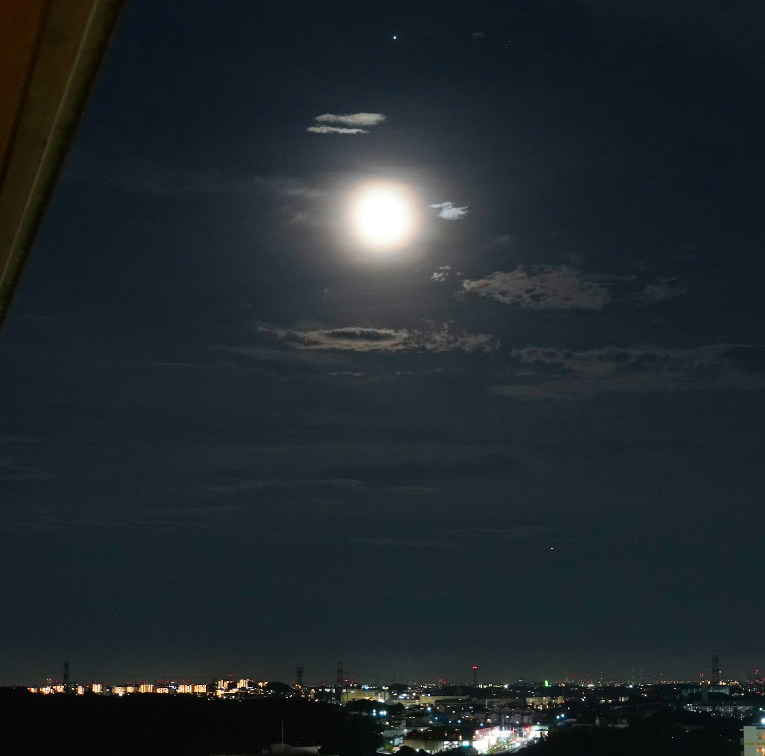明亮的滿月透過雲層在夜空中