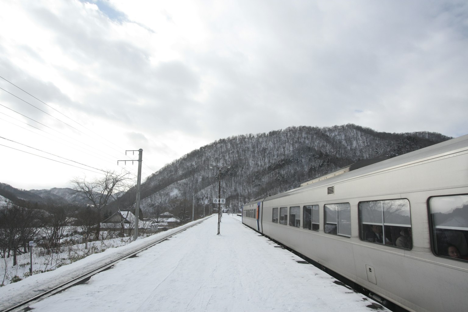 被雪覆盖的火车站台，背景是山