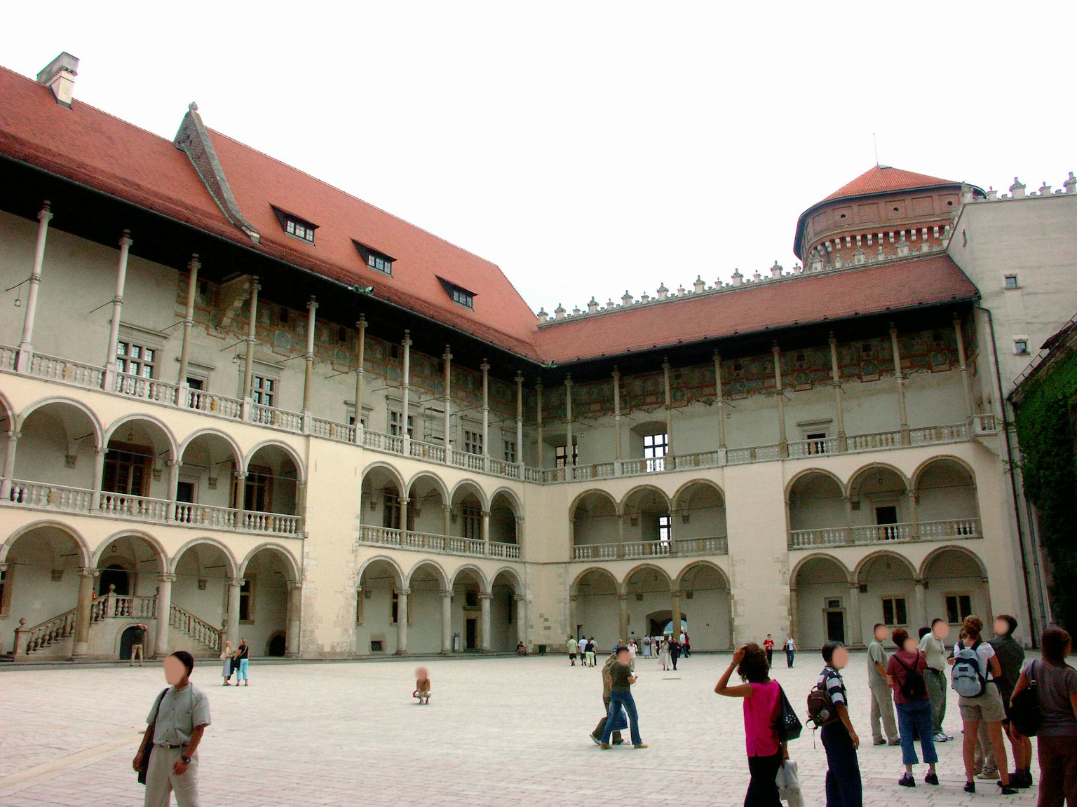 Interior de castillo histórico con patio y visitantes