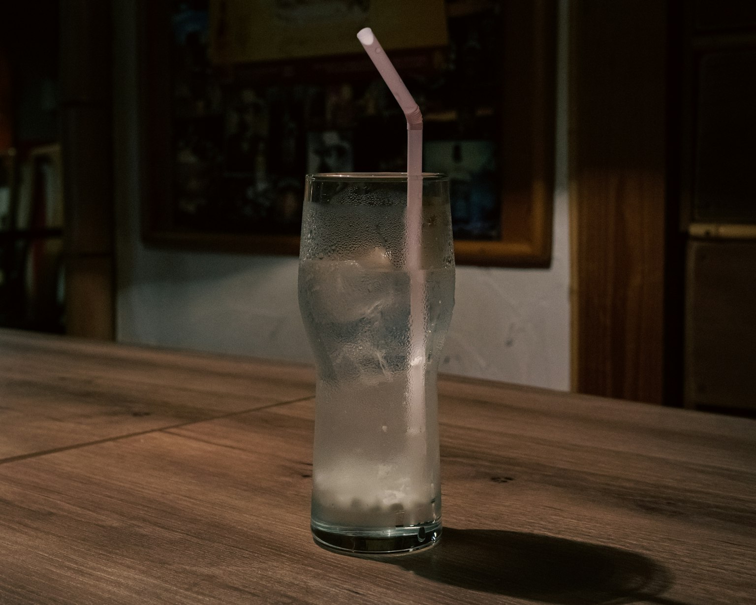 Un verre transparent avec de la glace et une paille