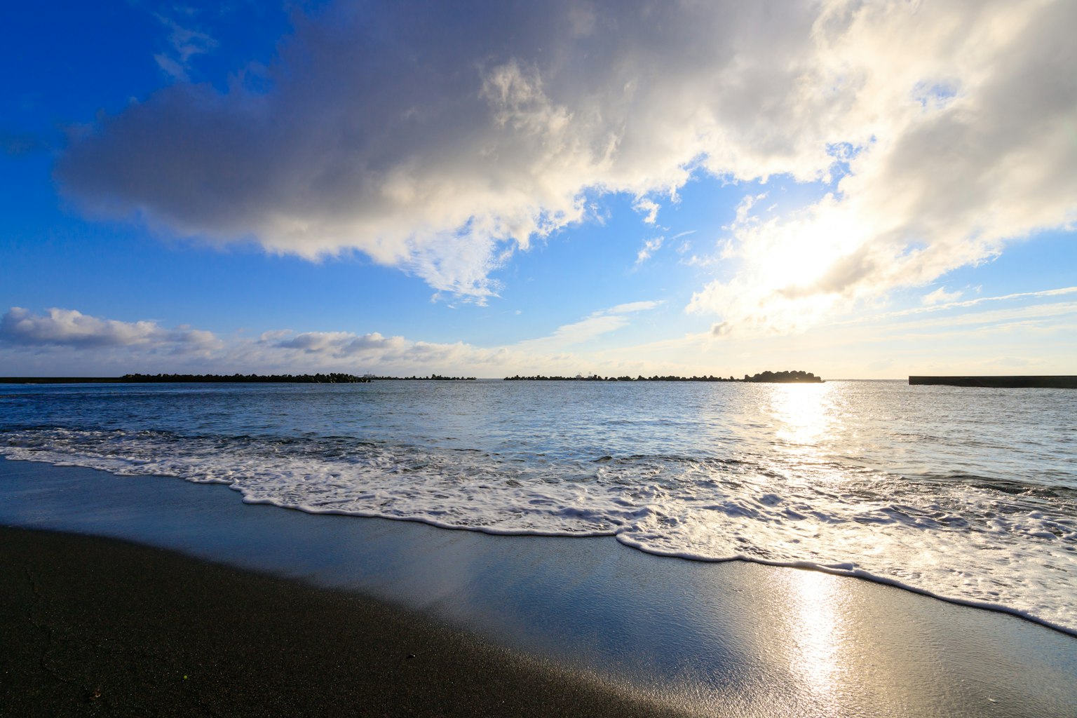 Strandszene mit blauem Himmel und Ozean, der Sonnenlicht reflektiert