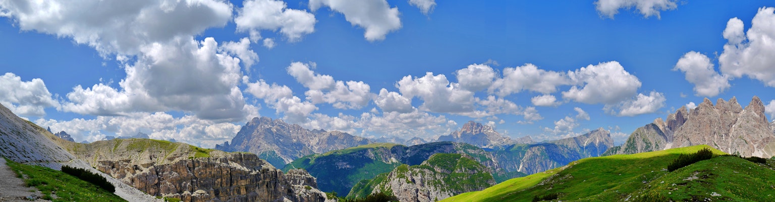 Panoramablick auf schöne Berge und blauen Himmel mit grünen Wiesen und weißen Wolken