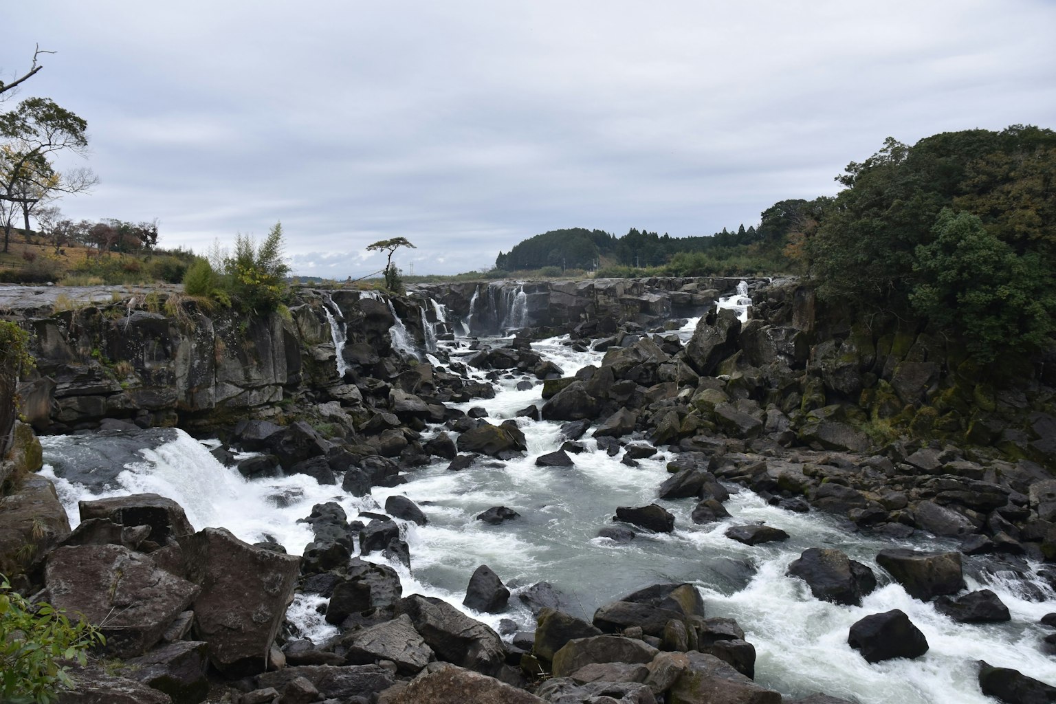Vista panoramica di un fiume con cascate e terreno roccioso