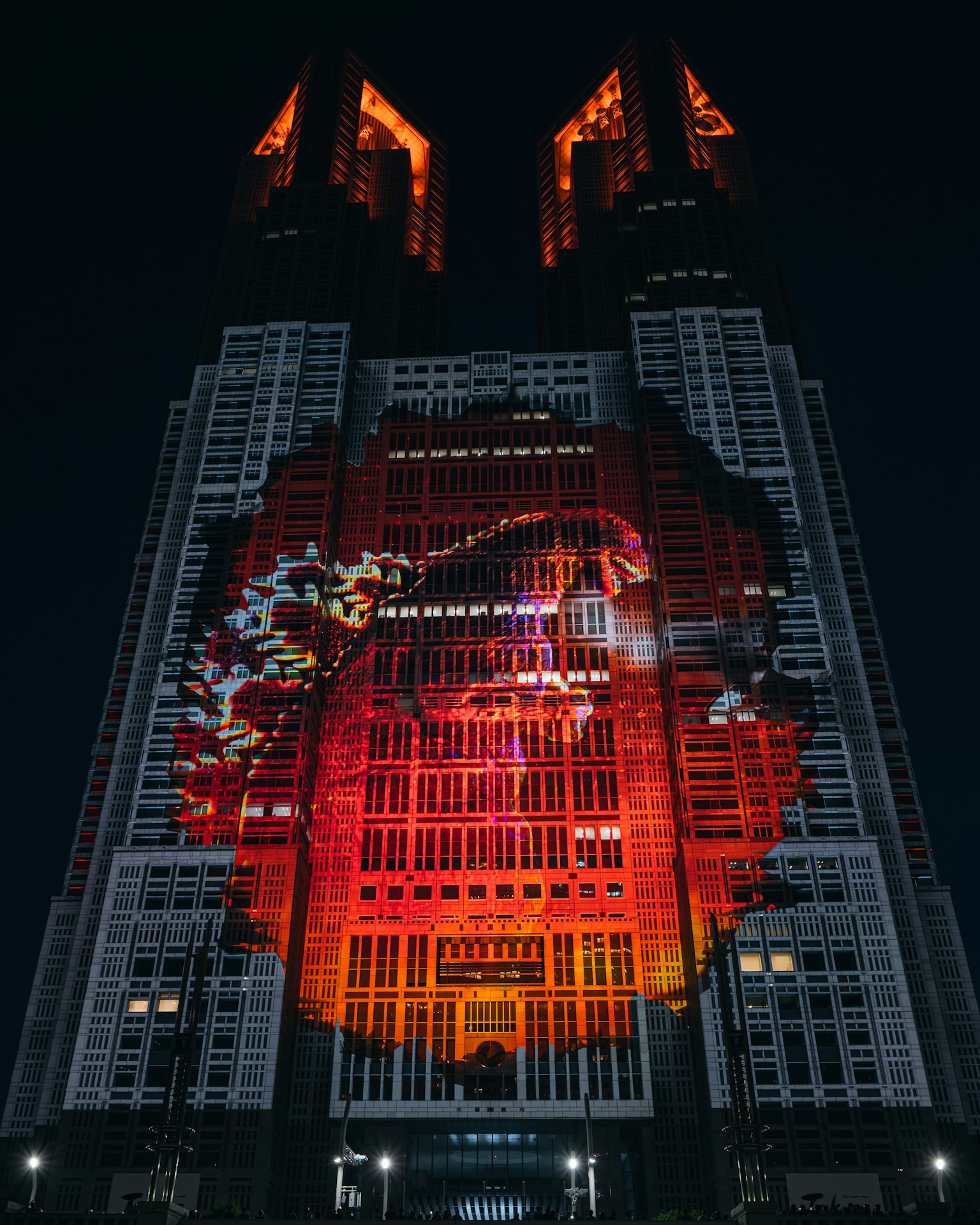 Hochhaus, das nachts von einer roten Drachenprojektion beleuchtet wird