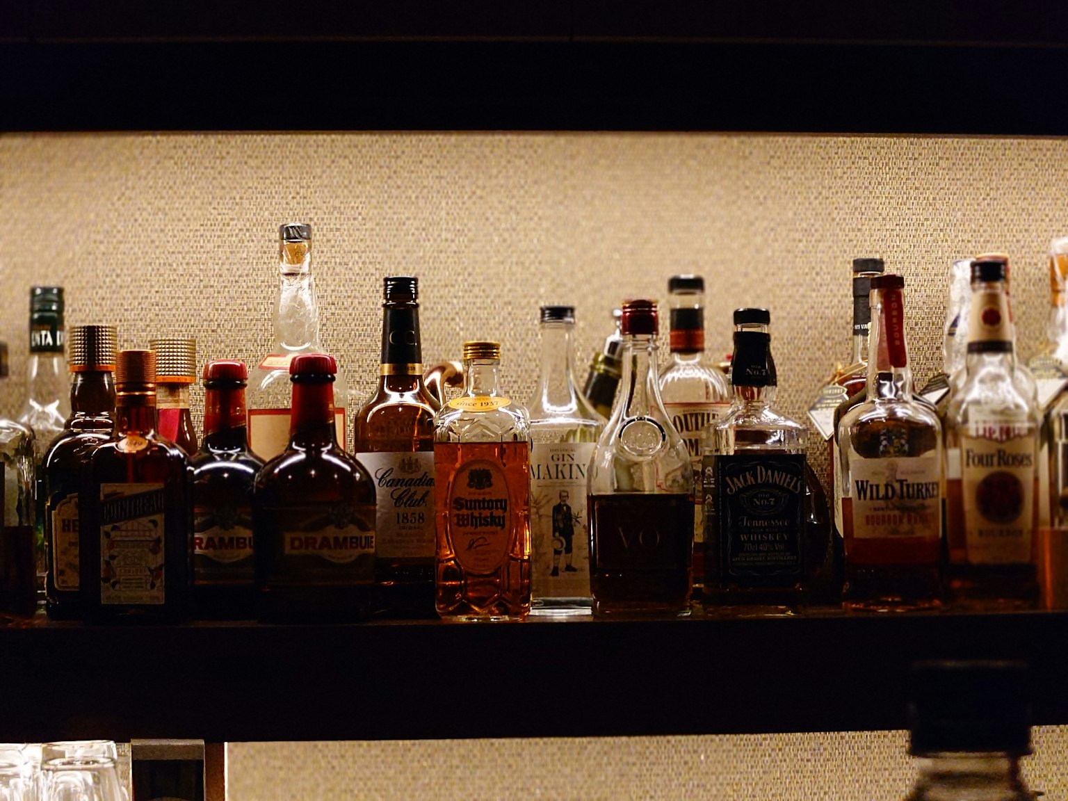 Una varietà di bottiglie di whisky esposte su uno scaffale