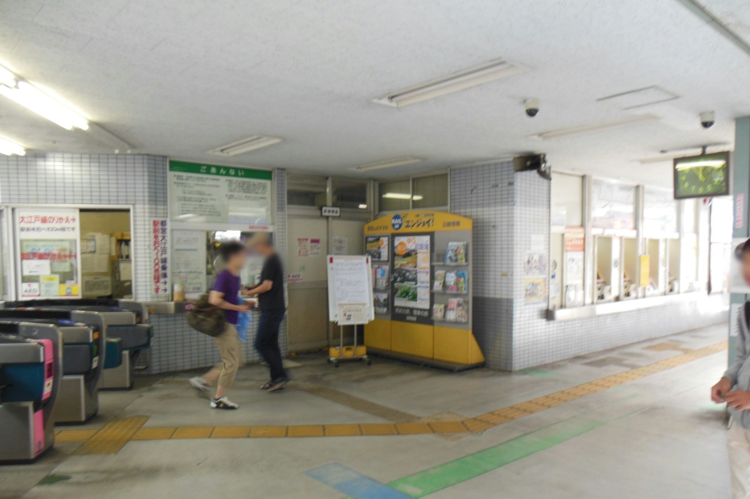 ภายในสถานีรถไฟแสดงประตูตั๋วและพื้นที่รอพร้อมผู้คน