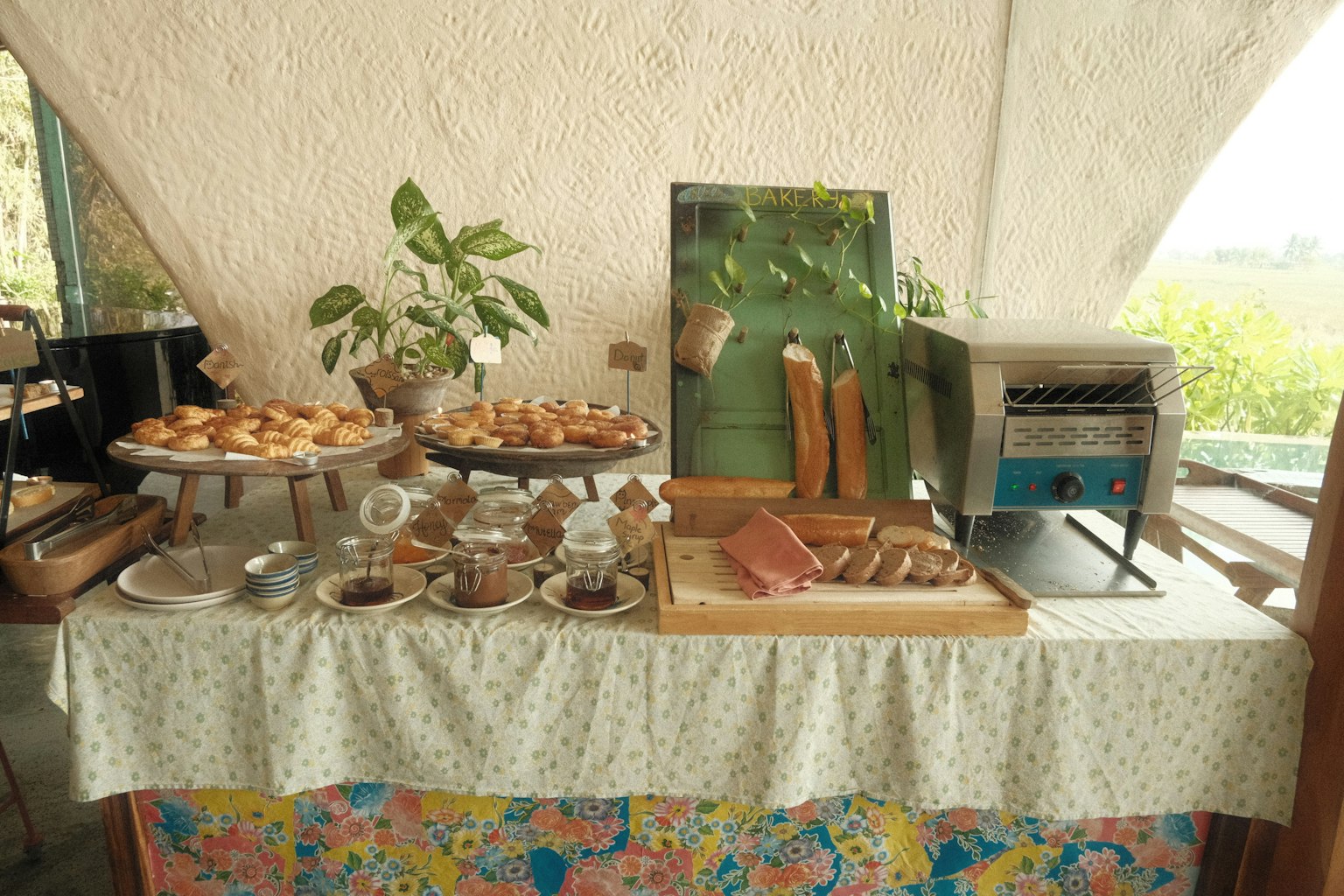 テーブルに並べられた焼きたてのパンとスイーツのビュッフェスタイルの朝食