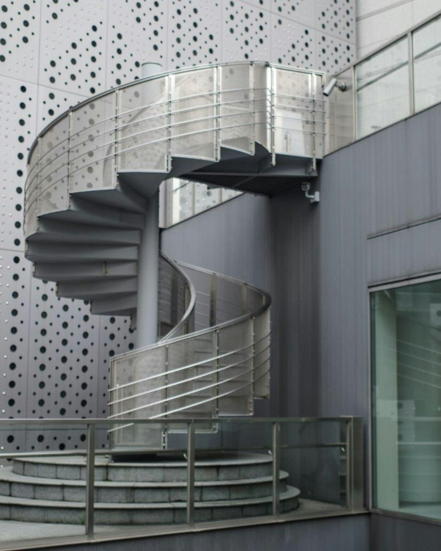 Modern building exterior featuring a spiral metal staircase