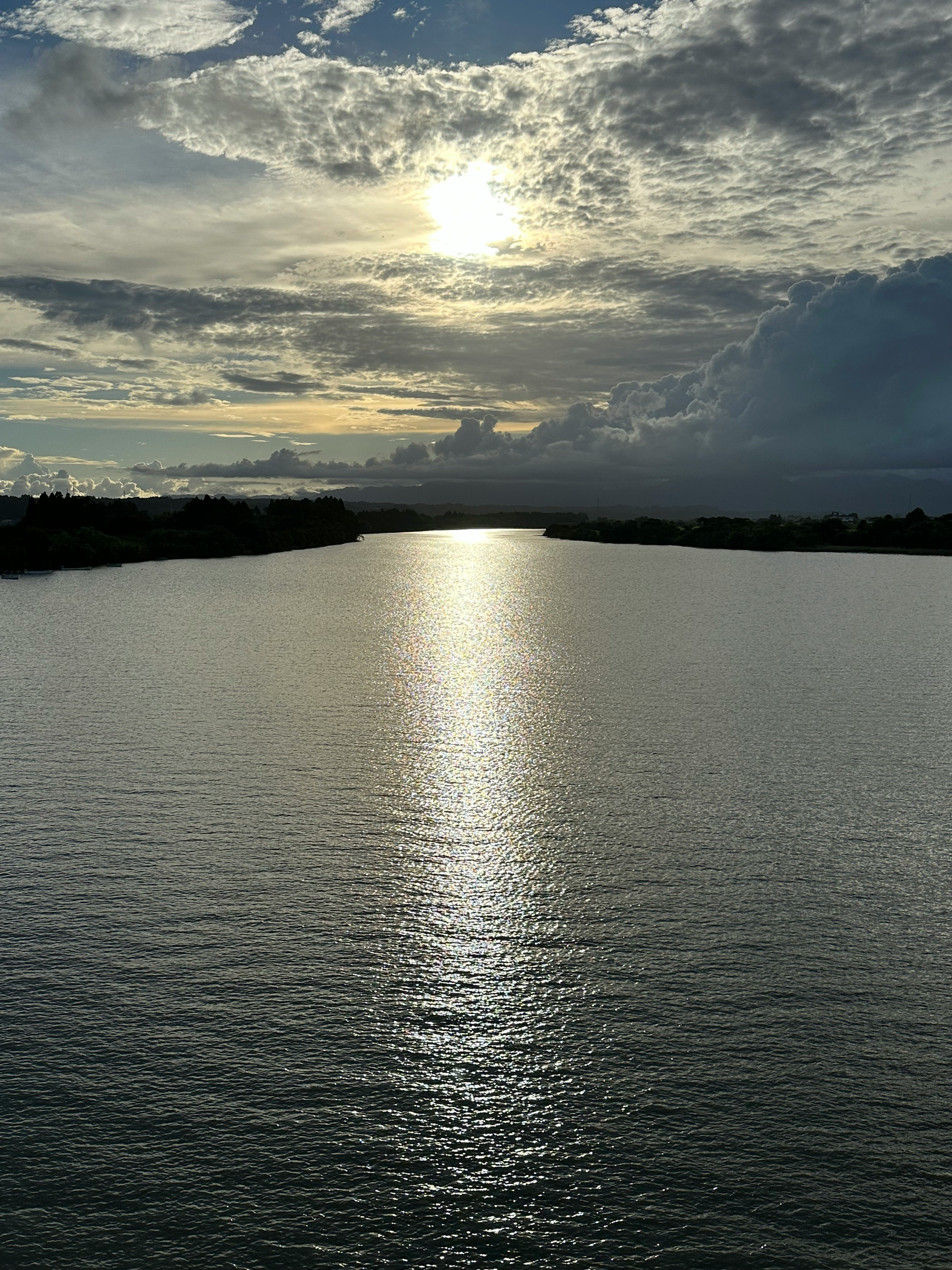 luz del atardecer reflejada en un río con cielo nublado