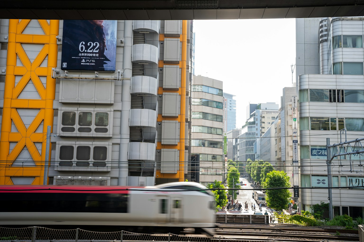 Cityscape featuring modern skyscrapers and a yellow building with a passing train