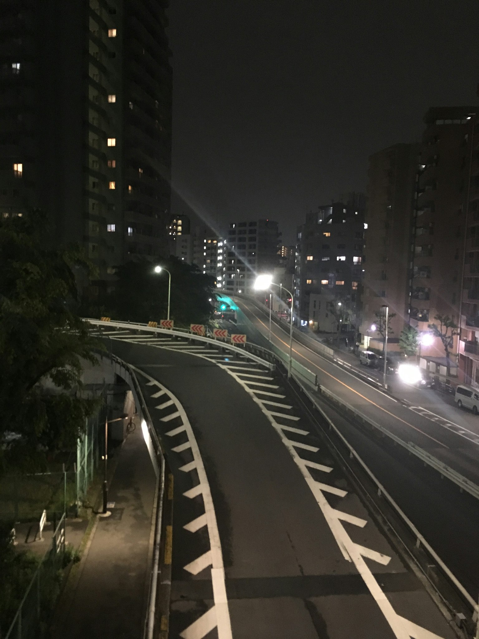 Kurvige Straße bei Nacht beleuchtet mit umliegenden Hochhäusern