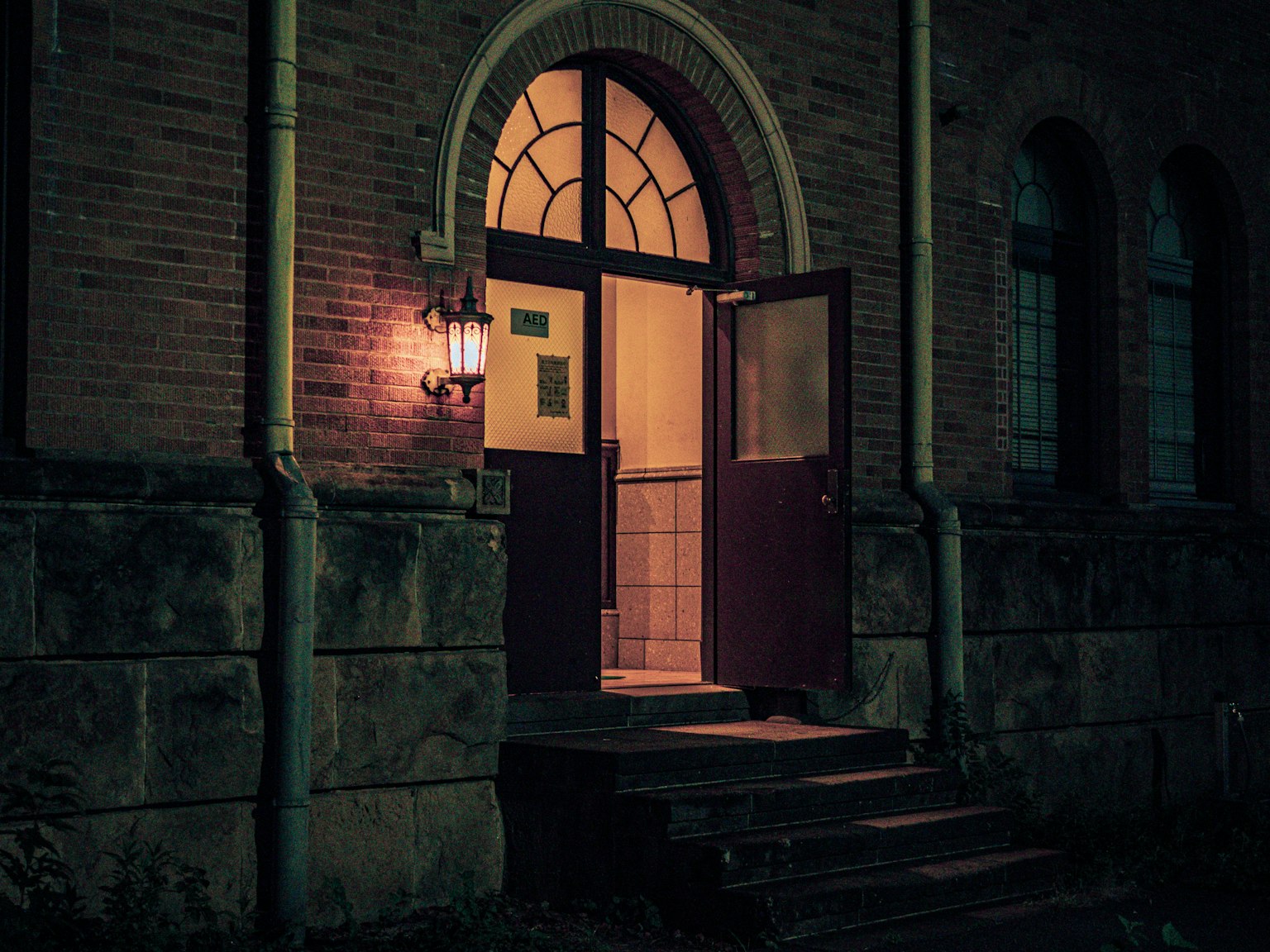 夜の建物の入り口 明かりがともるドアと階段