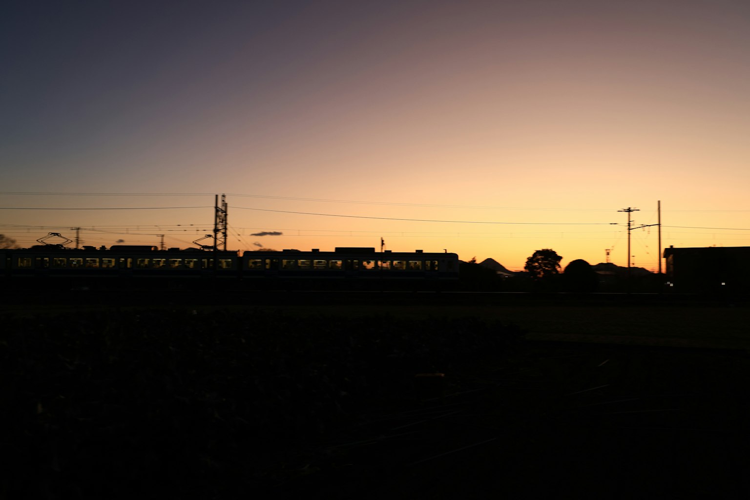 เงาของรถไฟและเสาสื่อสารในยามพระอาทิตย์ตก