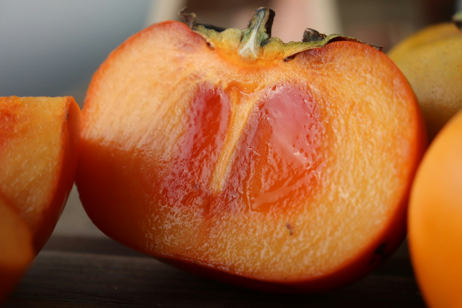Primo piano di un cachi tagliato a metà che mostra una polpa arancione e rossa vivace