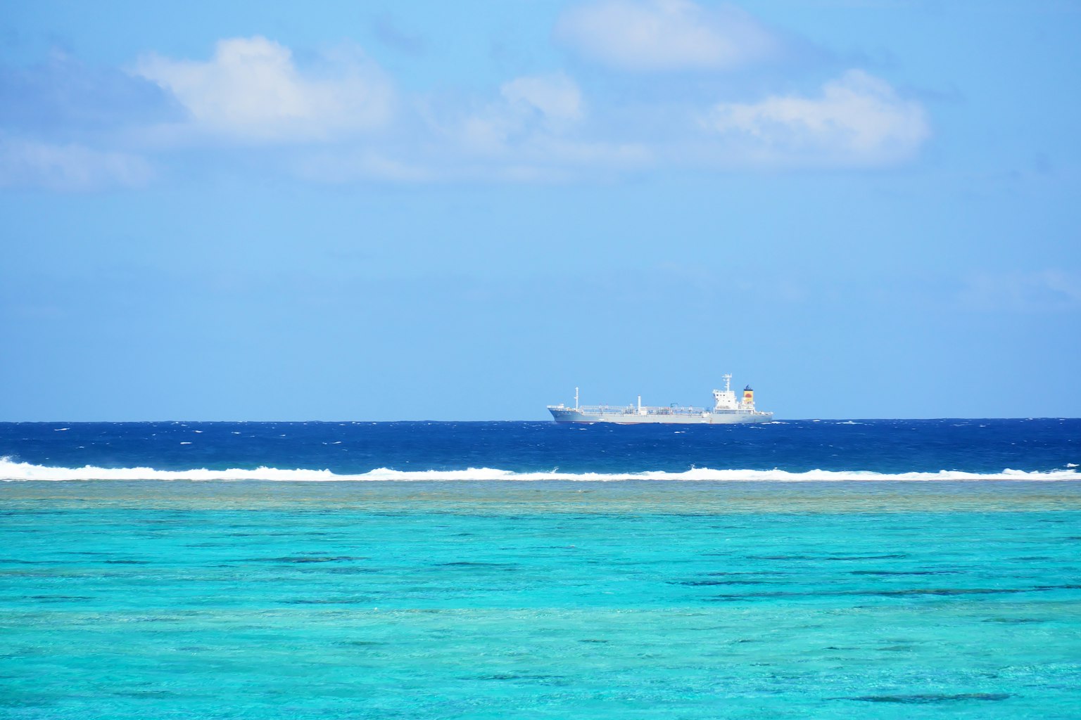 Une vue de l'océan bleu avec un bateau au loin