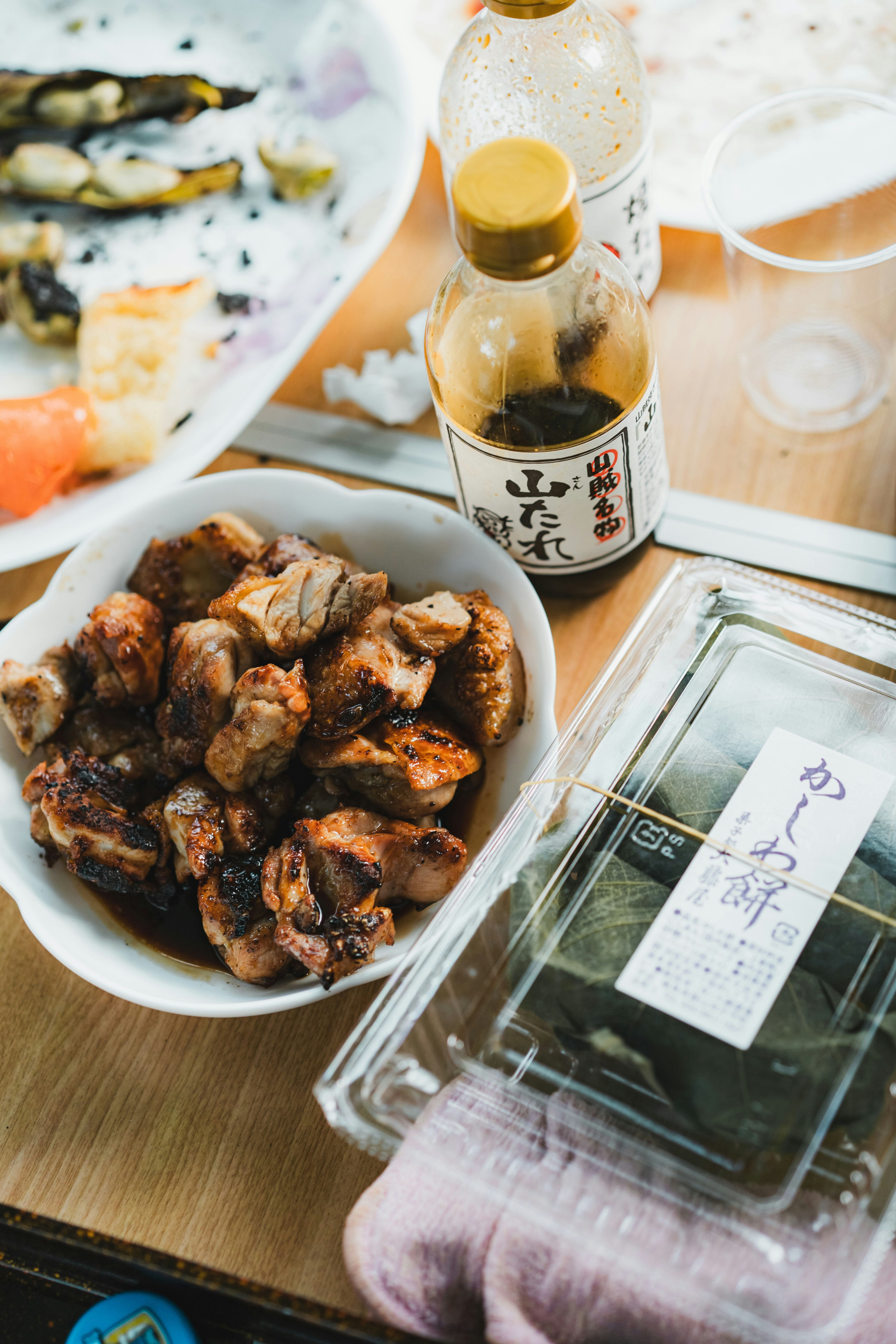 木桌上的烤鸡肉串和瓶装啤酒