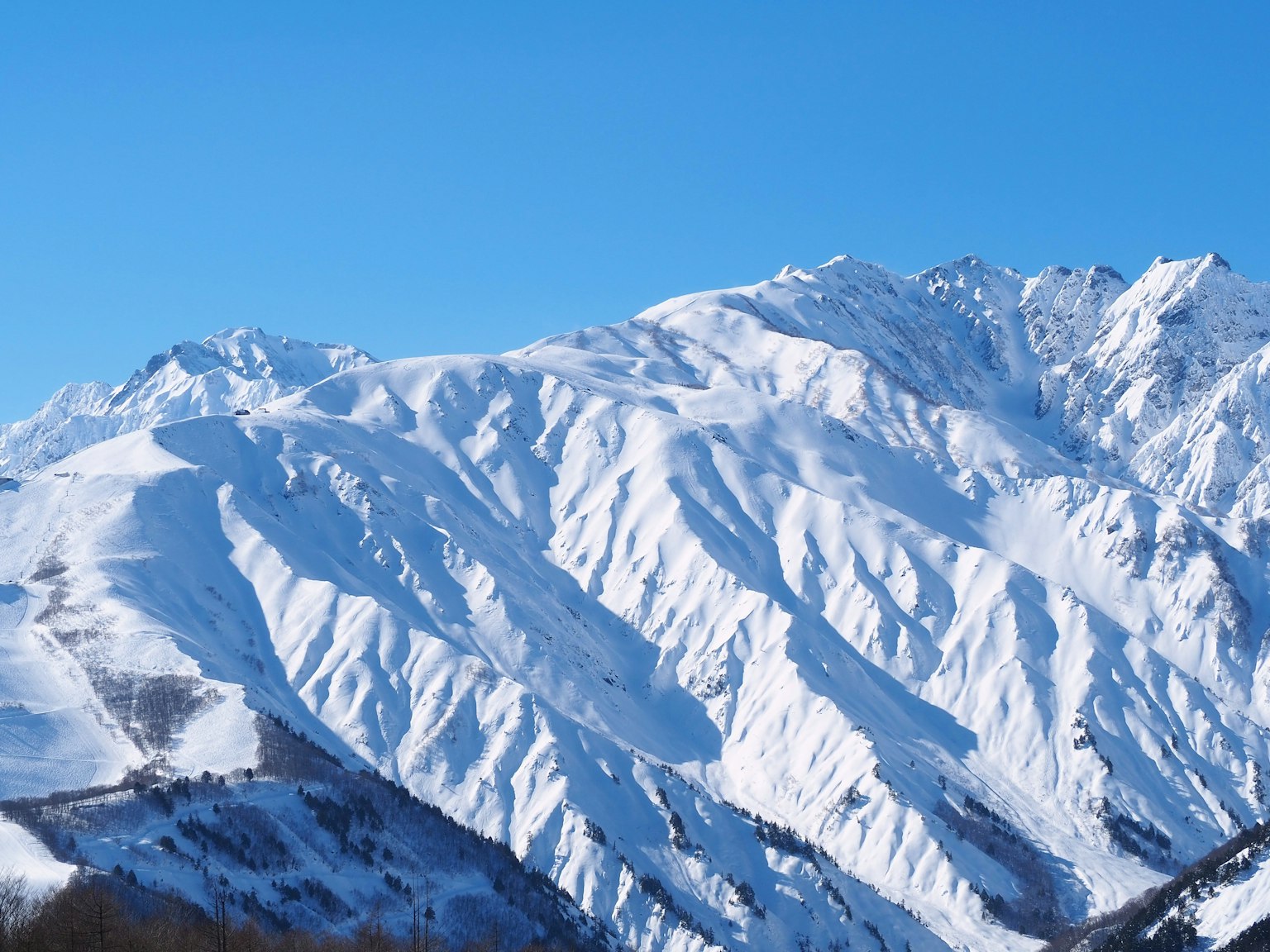 Montagne innevate sotto un cielo blu chiaro