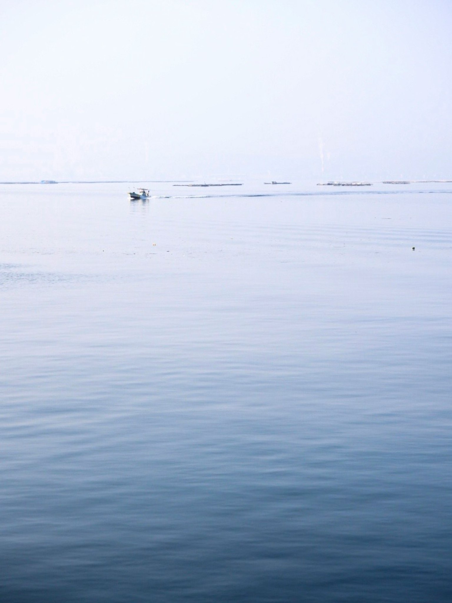 Mare calmo con una piccola barca in lontananza