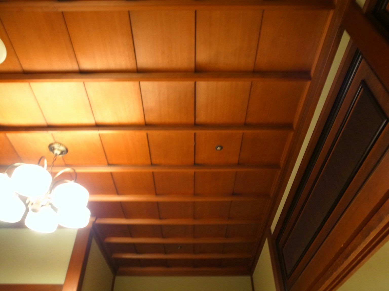 Soffitto in legno con un lampadario in uno spazio interno