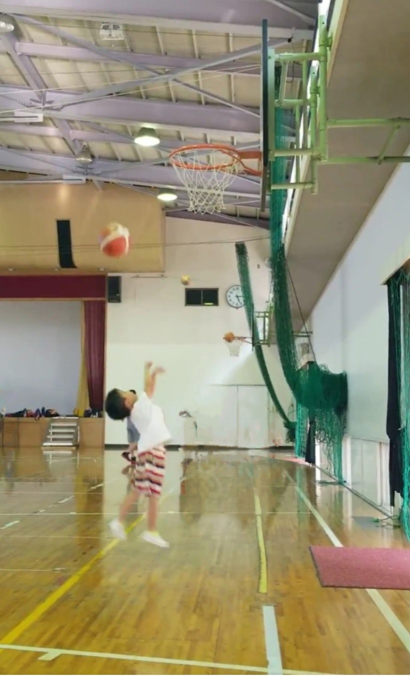 une personne s’entraînant à un tir au basket dans une salle de sport